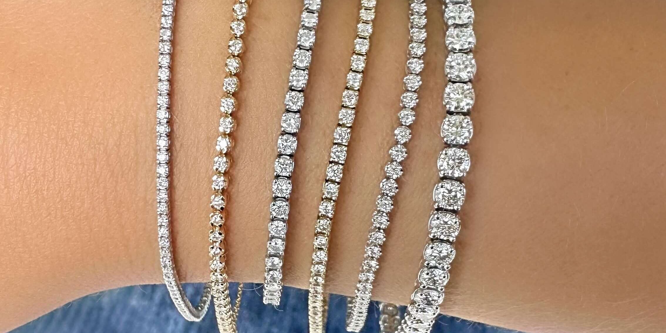 Collection of sparkling tennis bracelets in gold and silver displayed on a wrist, perfect for elegant occasions.