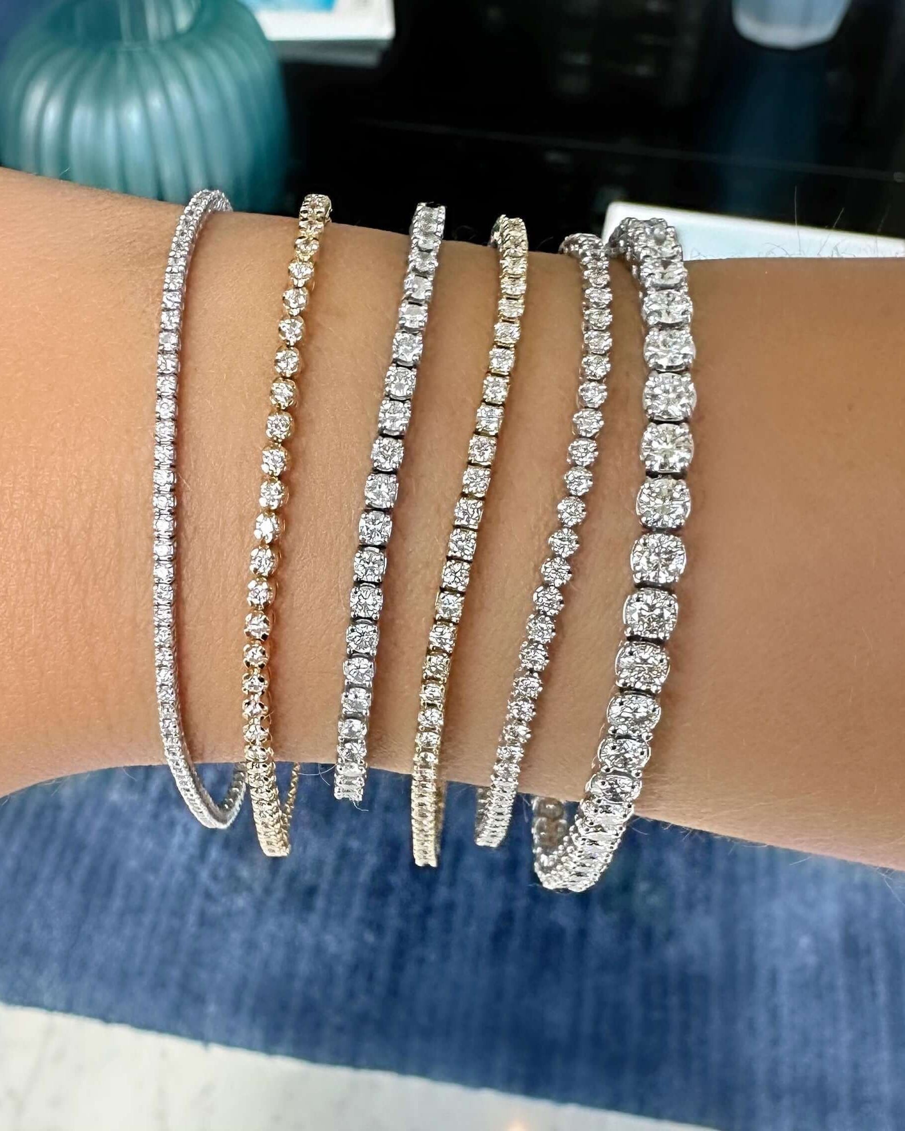Collection of sparkling tennis bracelets in gold and silver displayed on a wrist, perfect for elegant occasions.