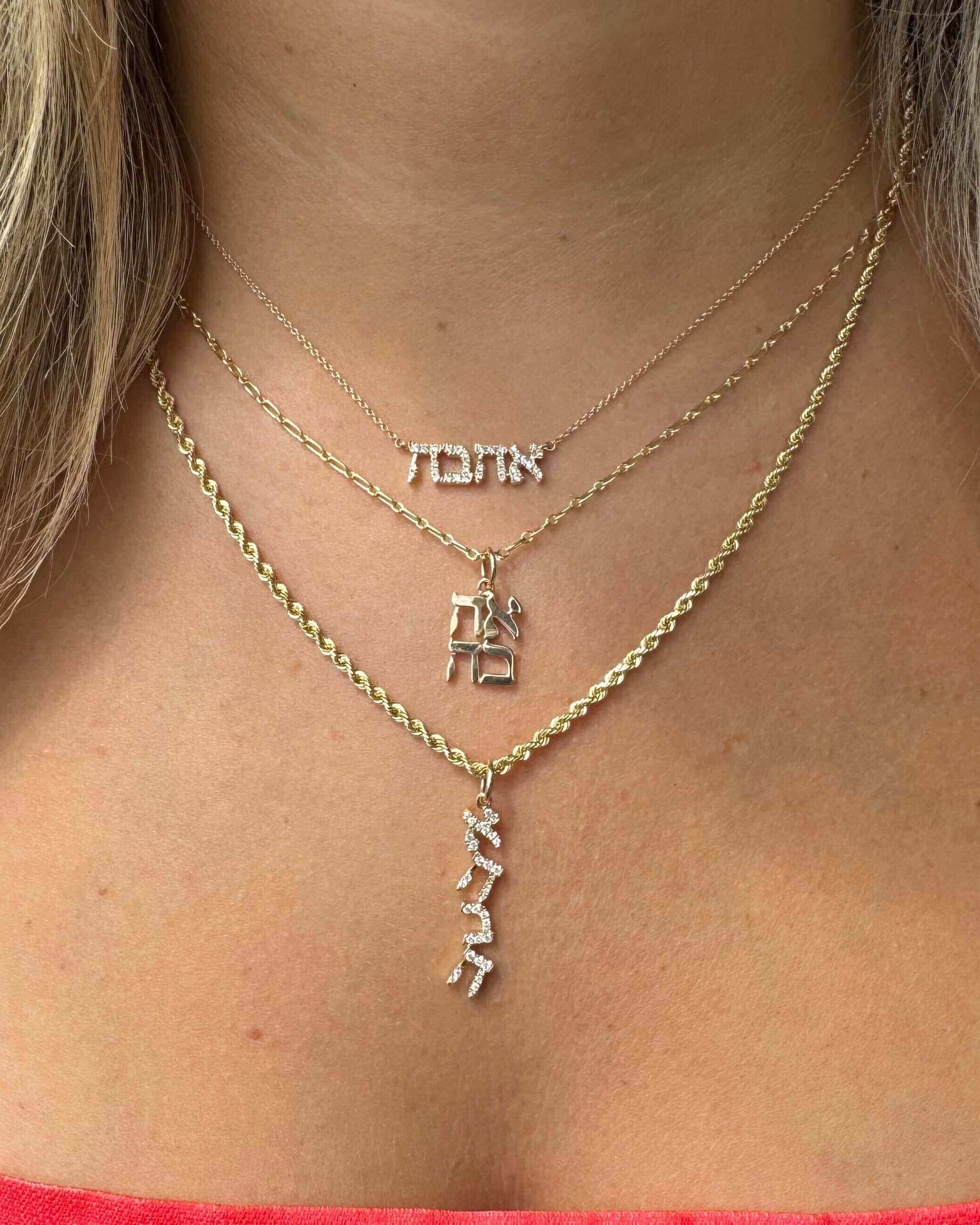 Gold Hebrew necklaces meaning love, faith, and life, displayed beautifully on a woman's neck.