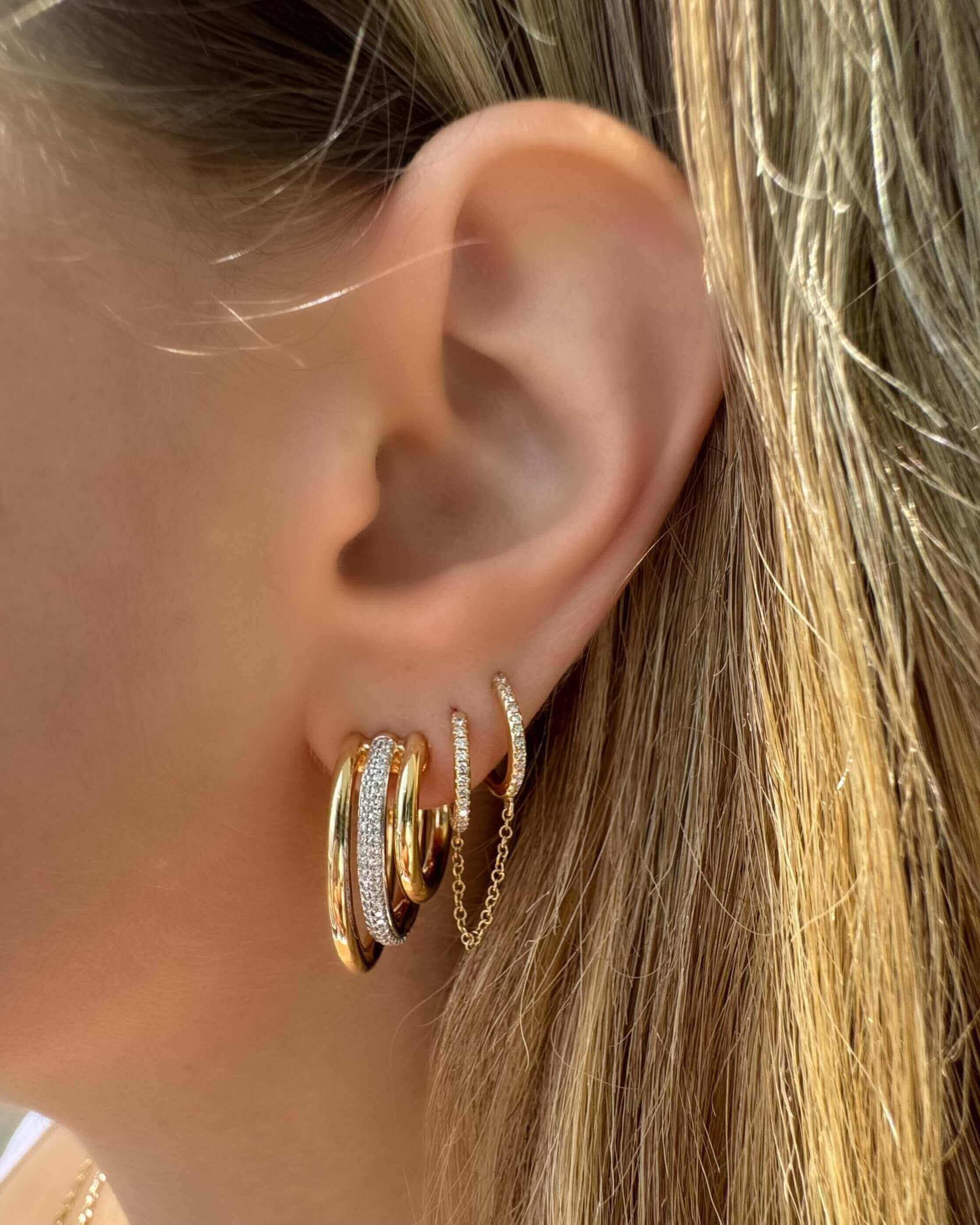 Chunky 3-Row Micro Pave Diamond J-Hoop Earrings displayed on a woman's ear, showcasing elegant design and shine.