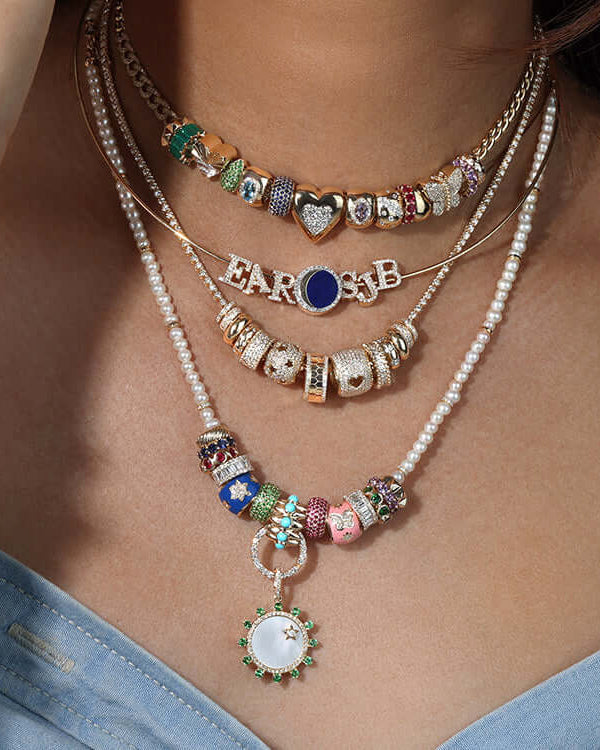 Stylish Rondelles necklaces layered on a model, featuring colorful beads and charms.