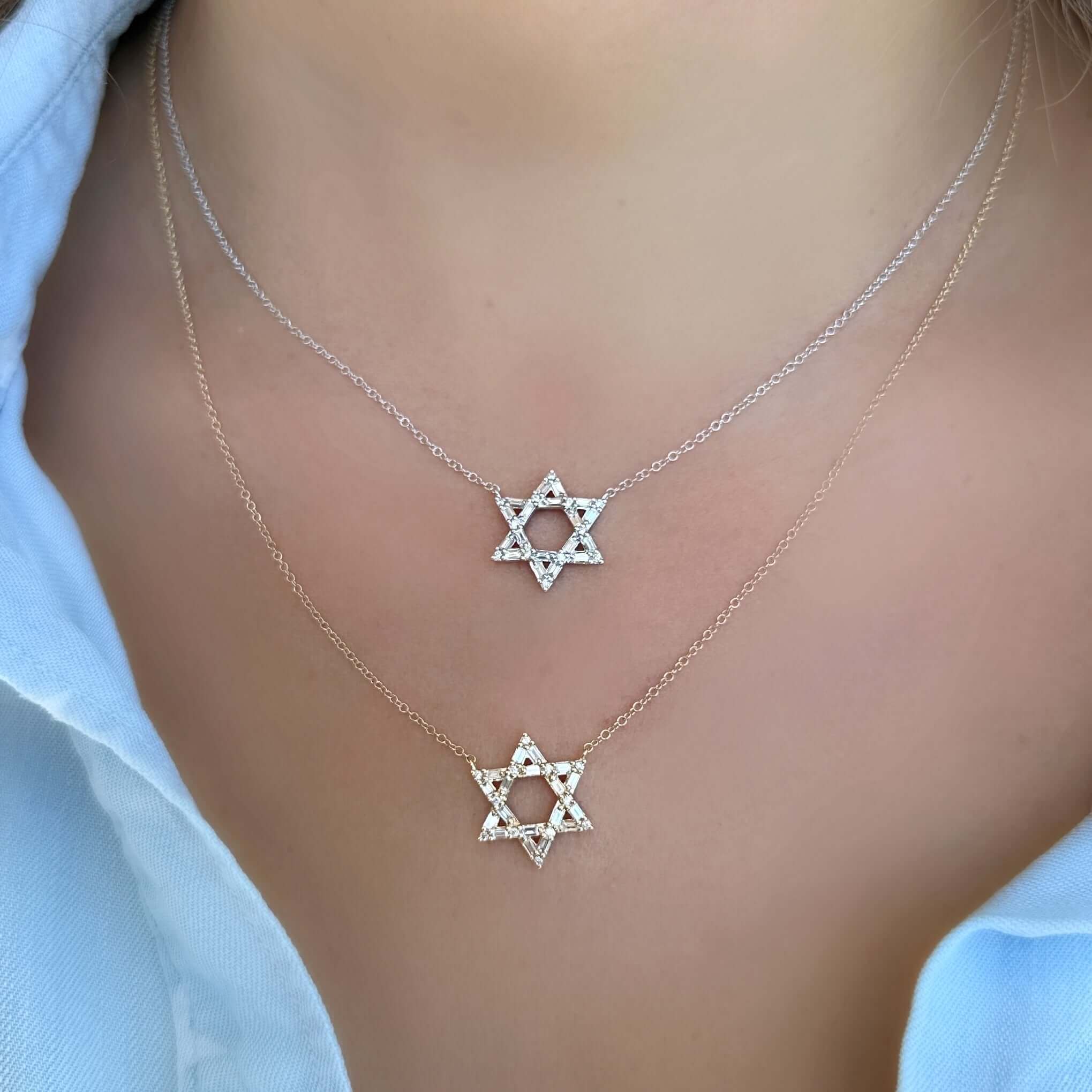 Woman wearing two Star of David pendant necklaces with delicate chains.