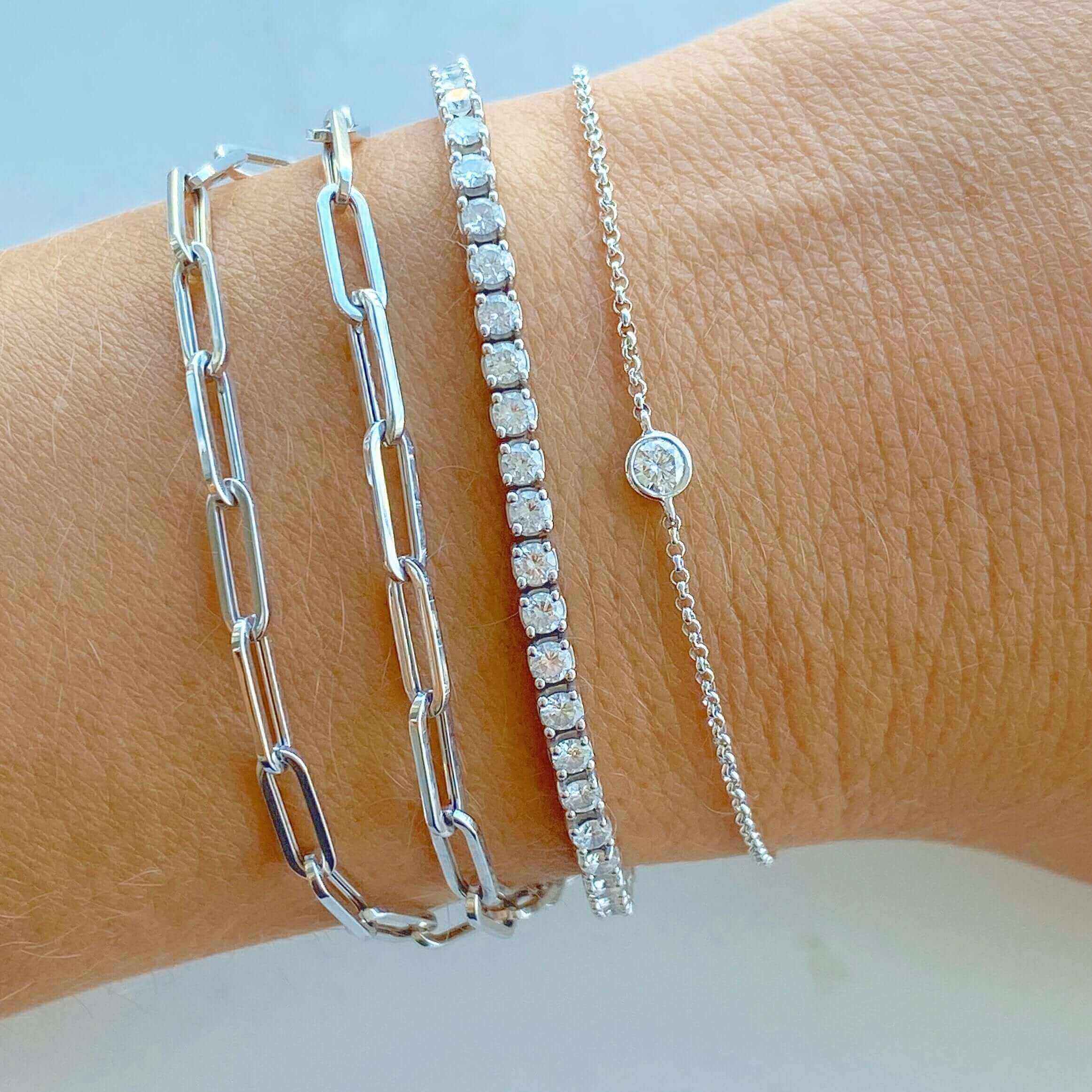 Modern and elegant silver chain and diamond bracelets stacked on wrist from our jewelry brand collection.