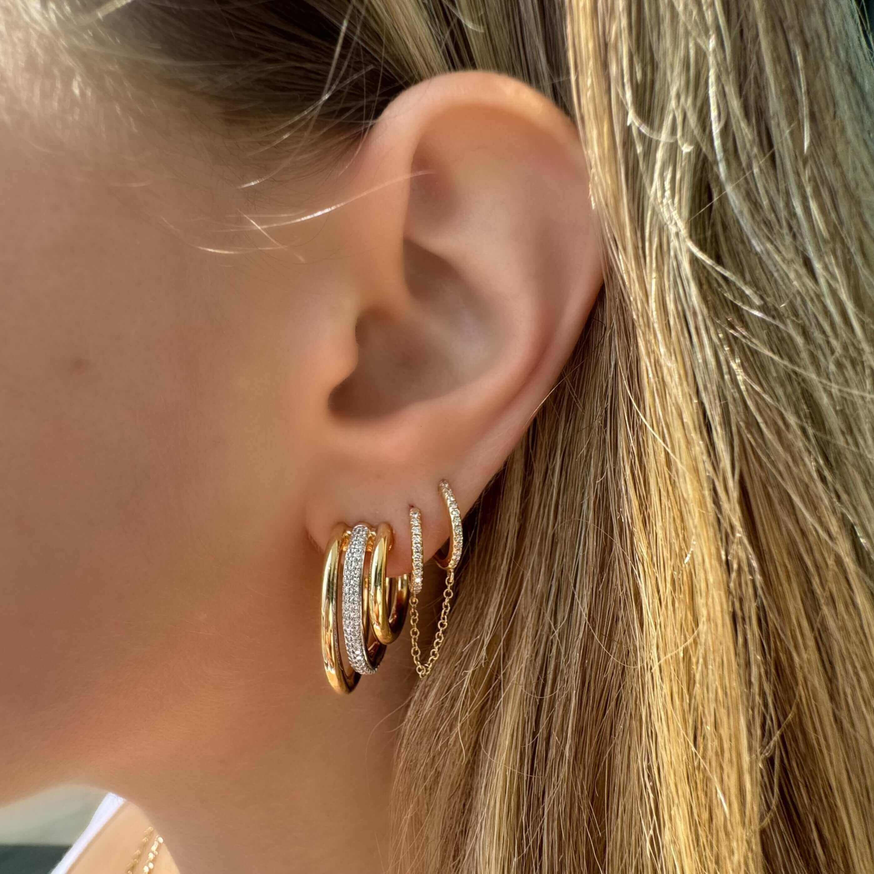 Chunky 3-Row Micro Pave Diamond J-Hoop Earrings displayed on a woman's ear, showcasing elegant design and shine.