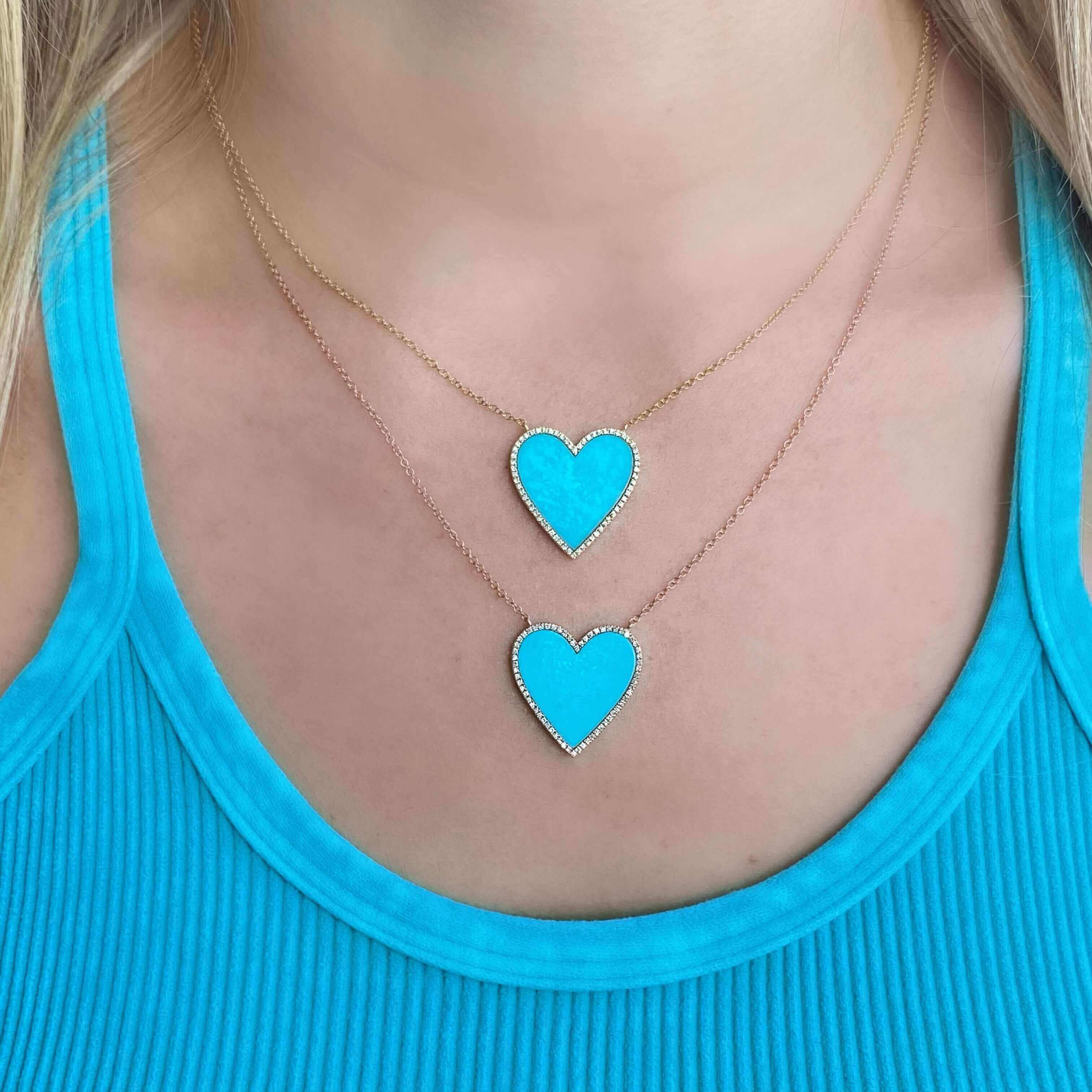 Double heart-shaped turquoise necklaces layered over a blue top from our jewelry collection.