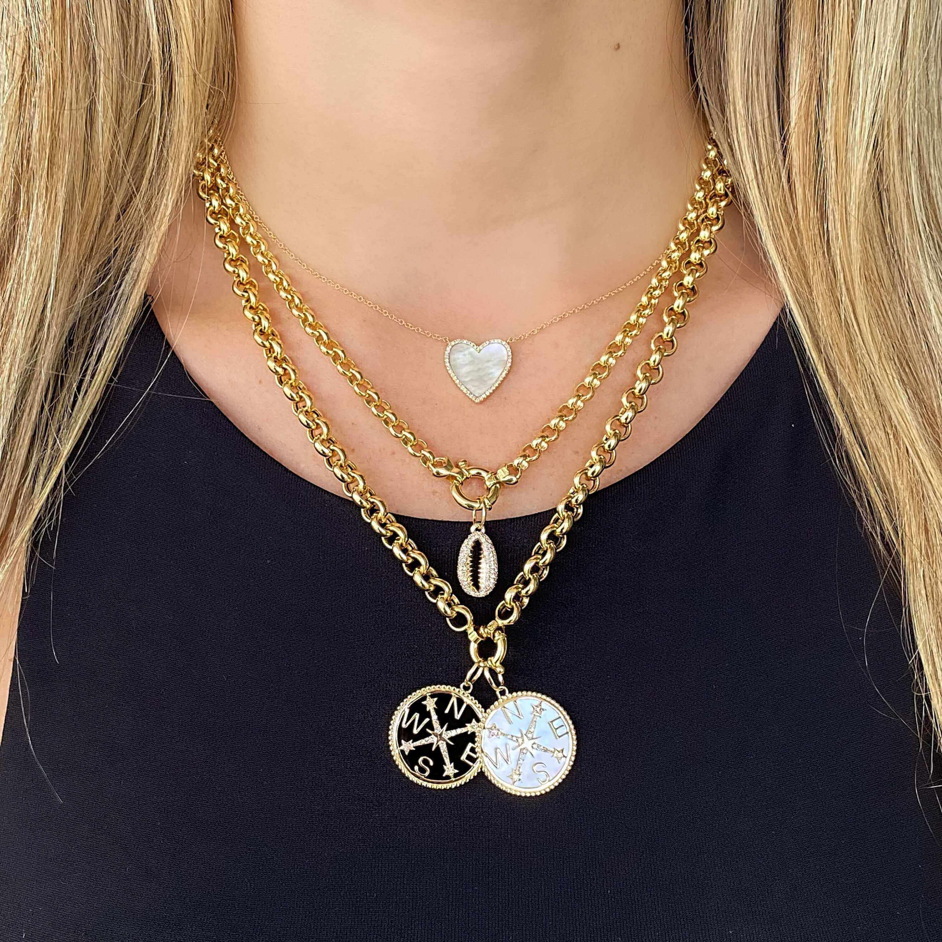 Layered gold necklaces featuring a heart pendant and personalized charms from our jewelry brand.