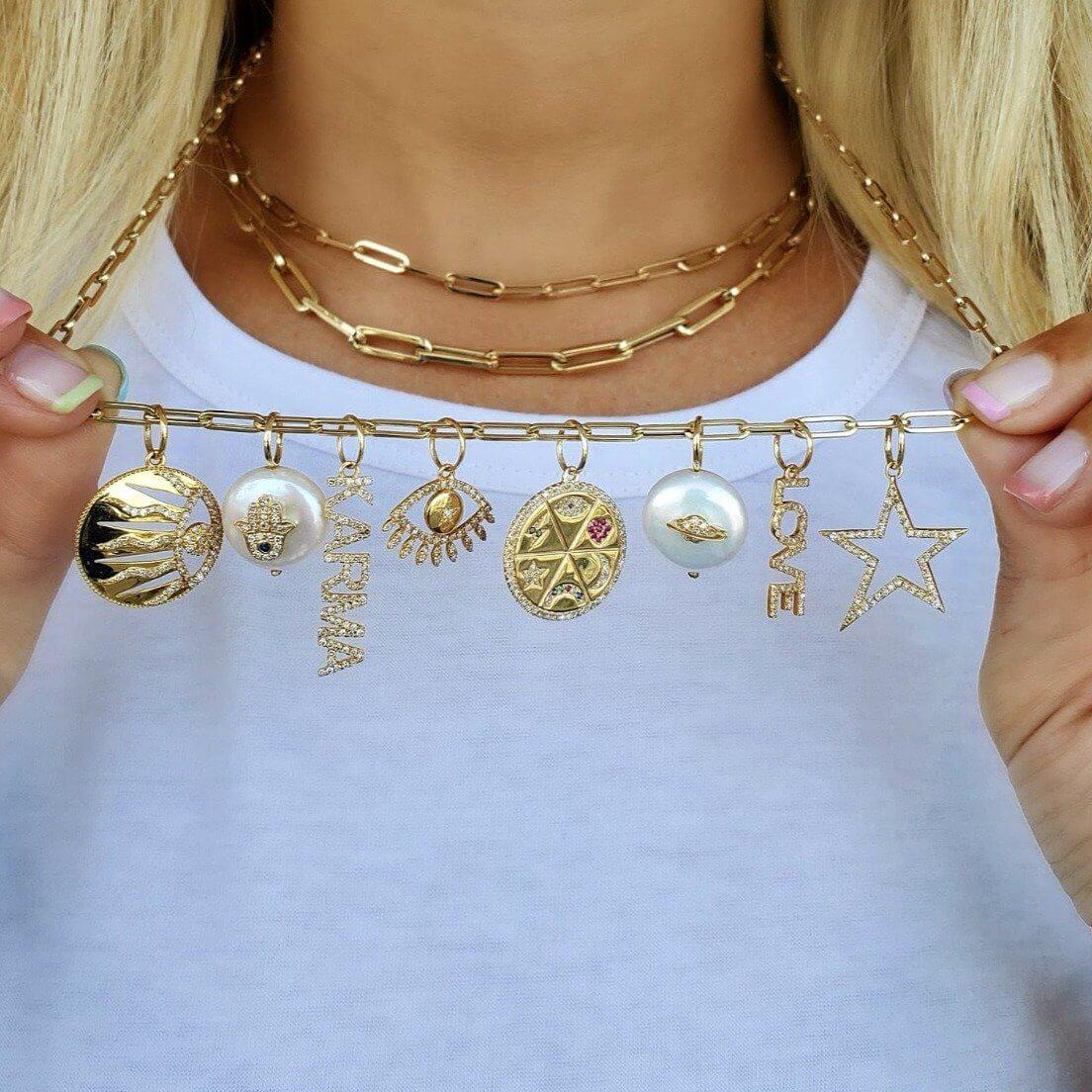 Gold charm bracelet with unique pendants and layered chain necklace showcasing the elegance of our jewelry brand.