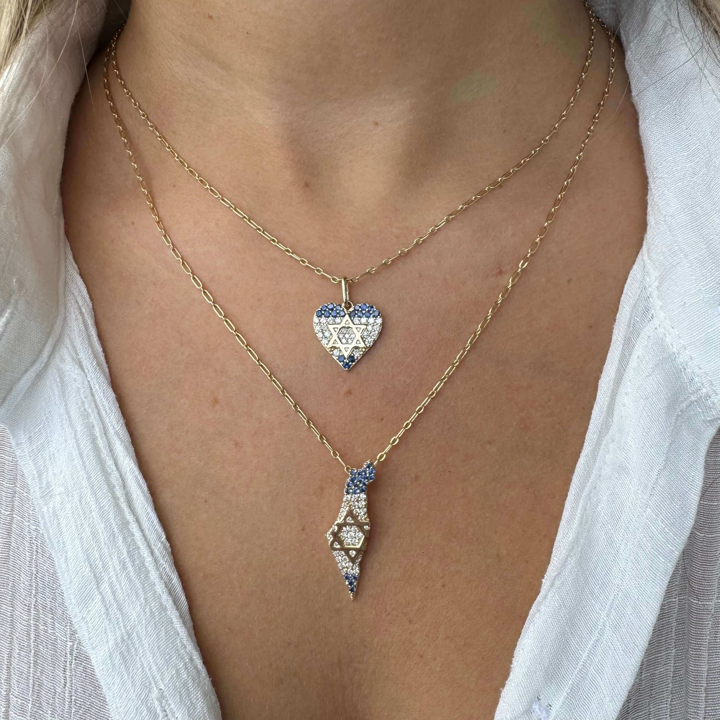 Elegant 14K gold necklace with heart and Israel-shaped pendants, featuring diamonds and sapphires for a stylish look.