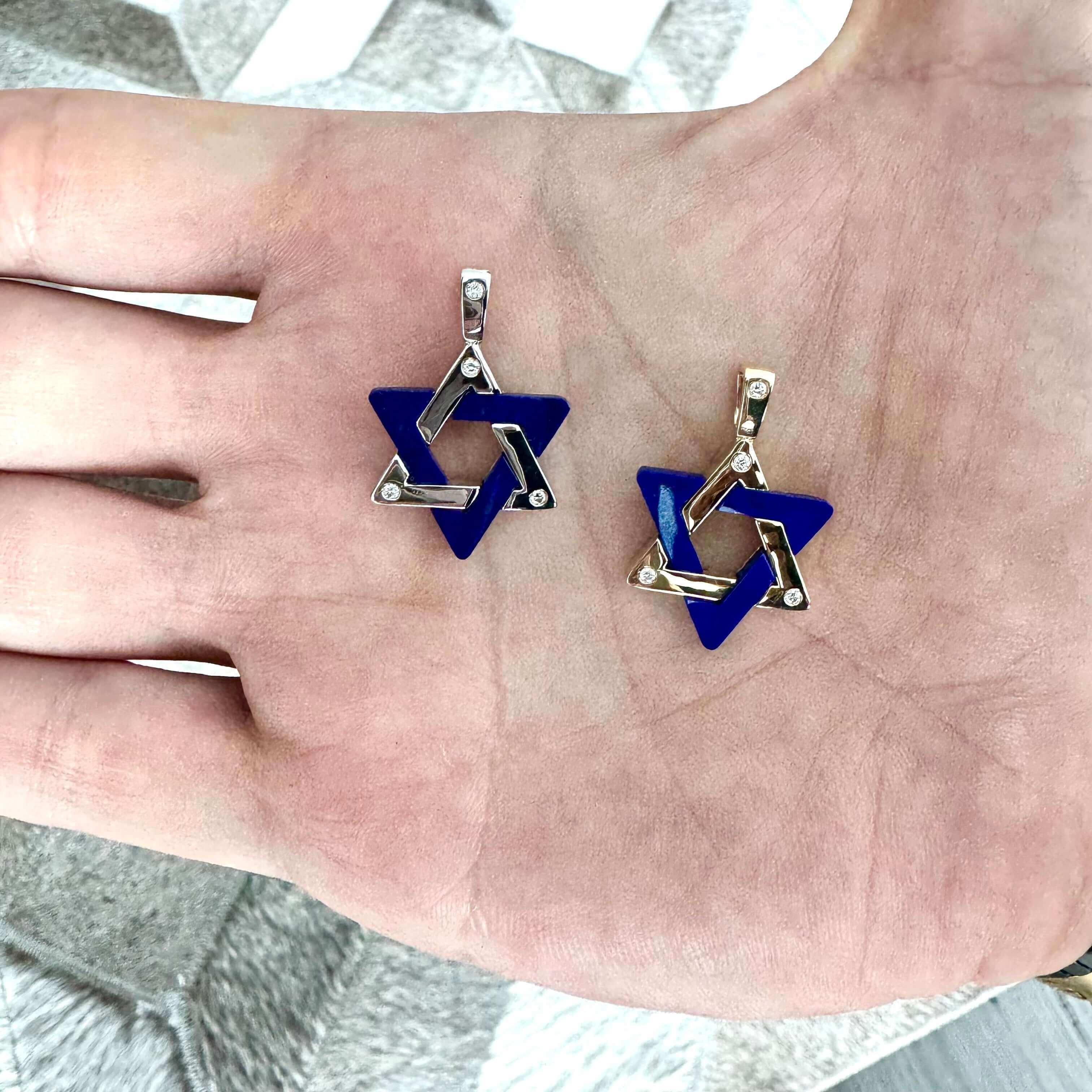 Hand holding Star of David-shaped jewelry pieces with geometric design and blue accents from our latest collection.