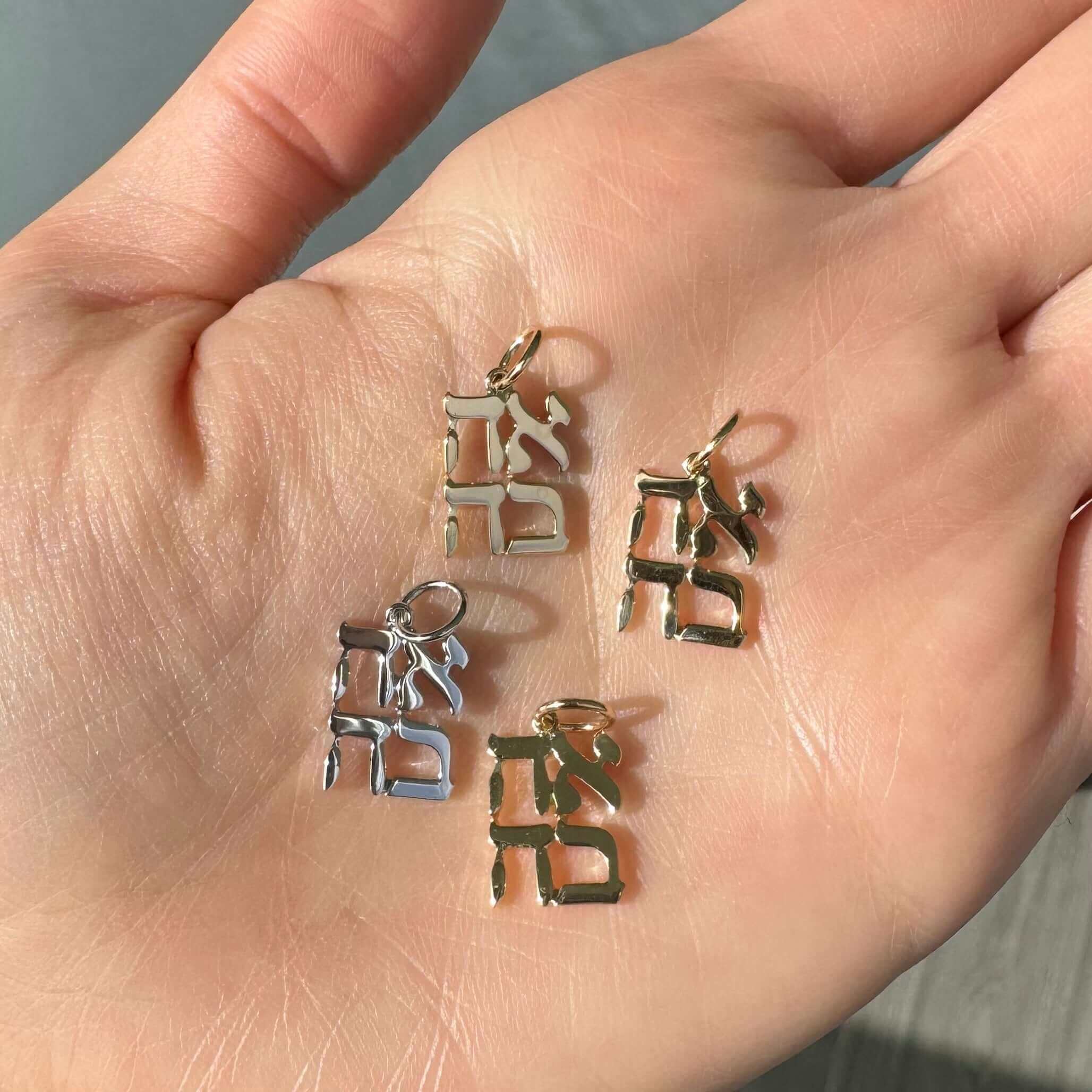 Hand displaying our unique gold and silver jewelry pendants from the latest collection - perfect for adding a touch of elegance to any outfit.