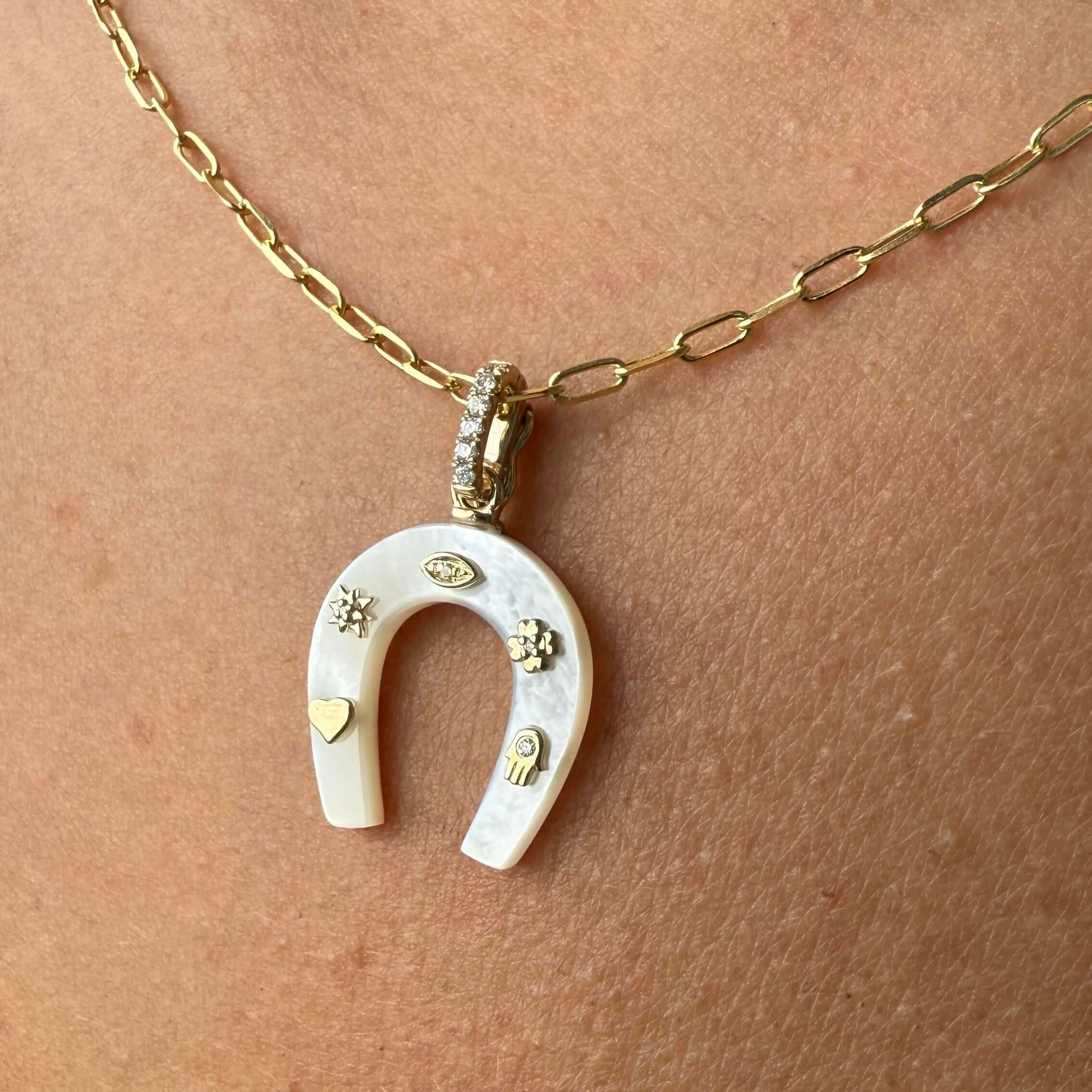 14K gold horseshoe gemstone pendant with diamond accents and lucky charms, showcasing mother of pearl design.