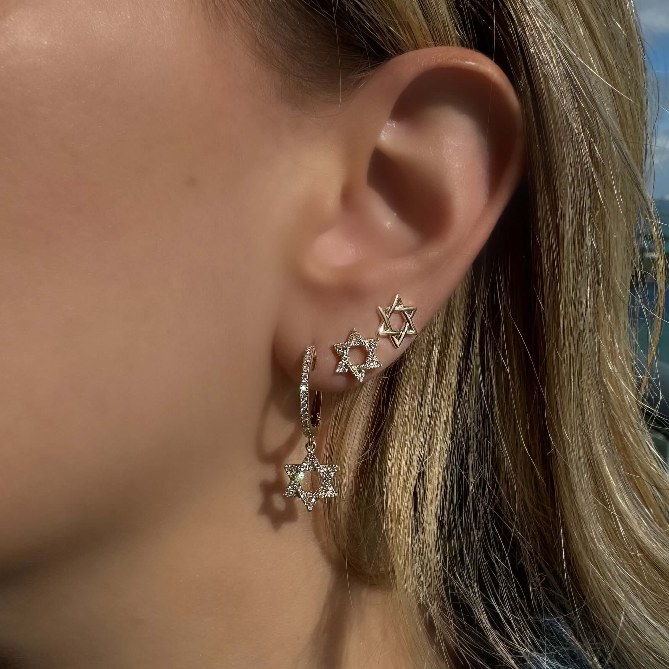 Micro Pave Diamond Star Of David Earrings showcased on a model, featuring shimmering diamonds in 14K gold.