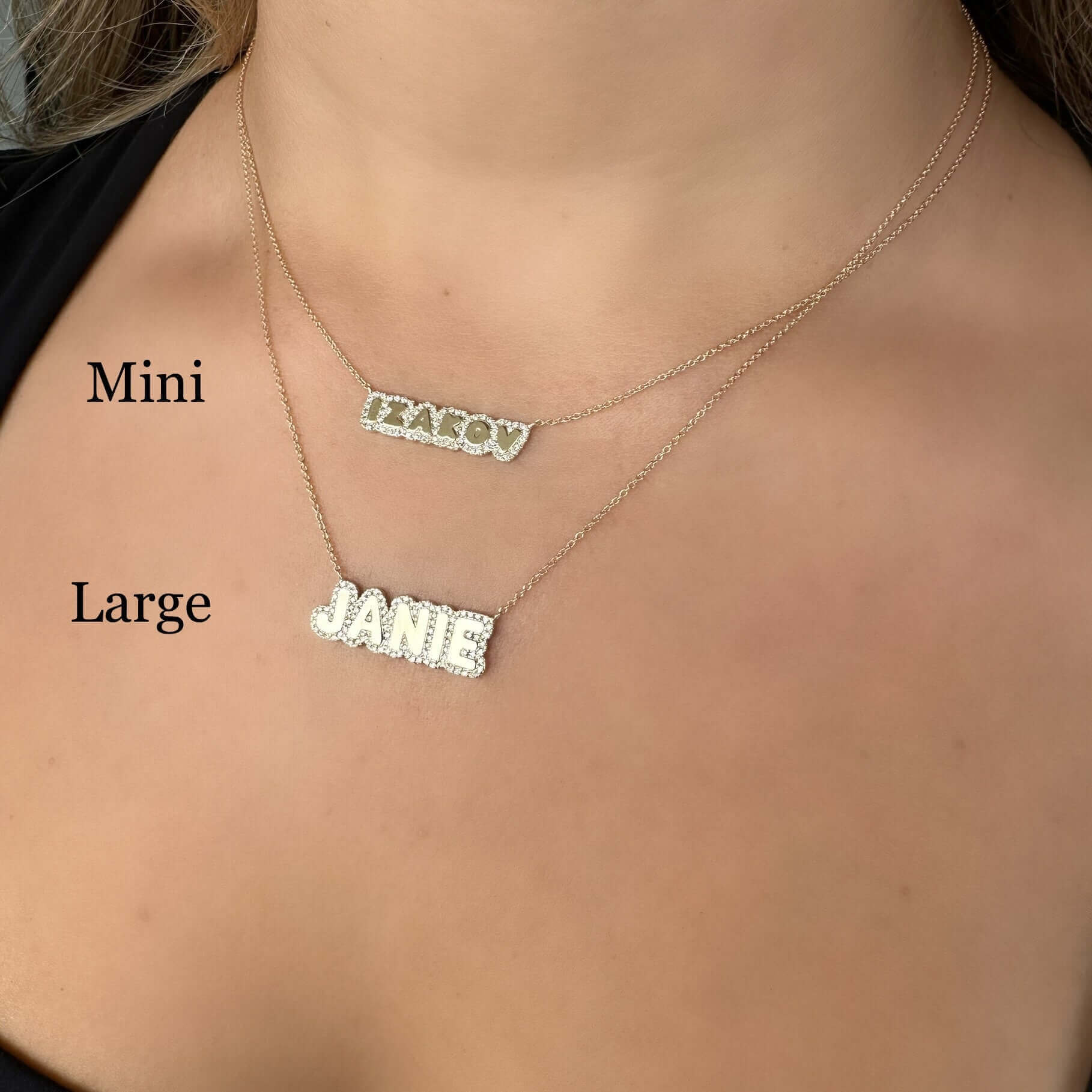 Woman wearing layered custom name necklaces, featuring mini and large personalized pendant designs by our jewelry brand.