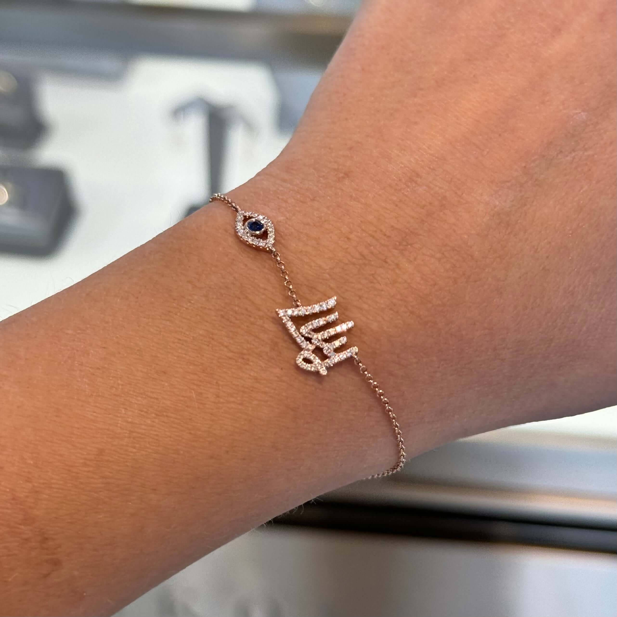 14K Gold Personalized Motif Diamond Script Nameplate Bracelet on a wrist with evil eye motif