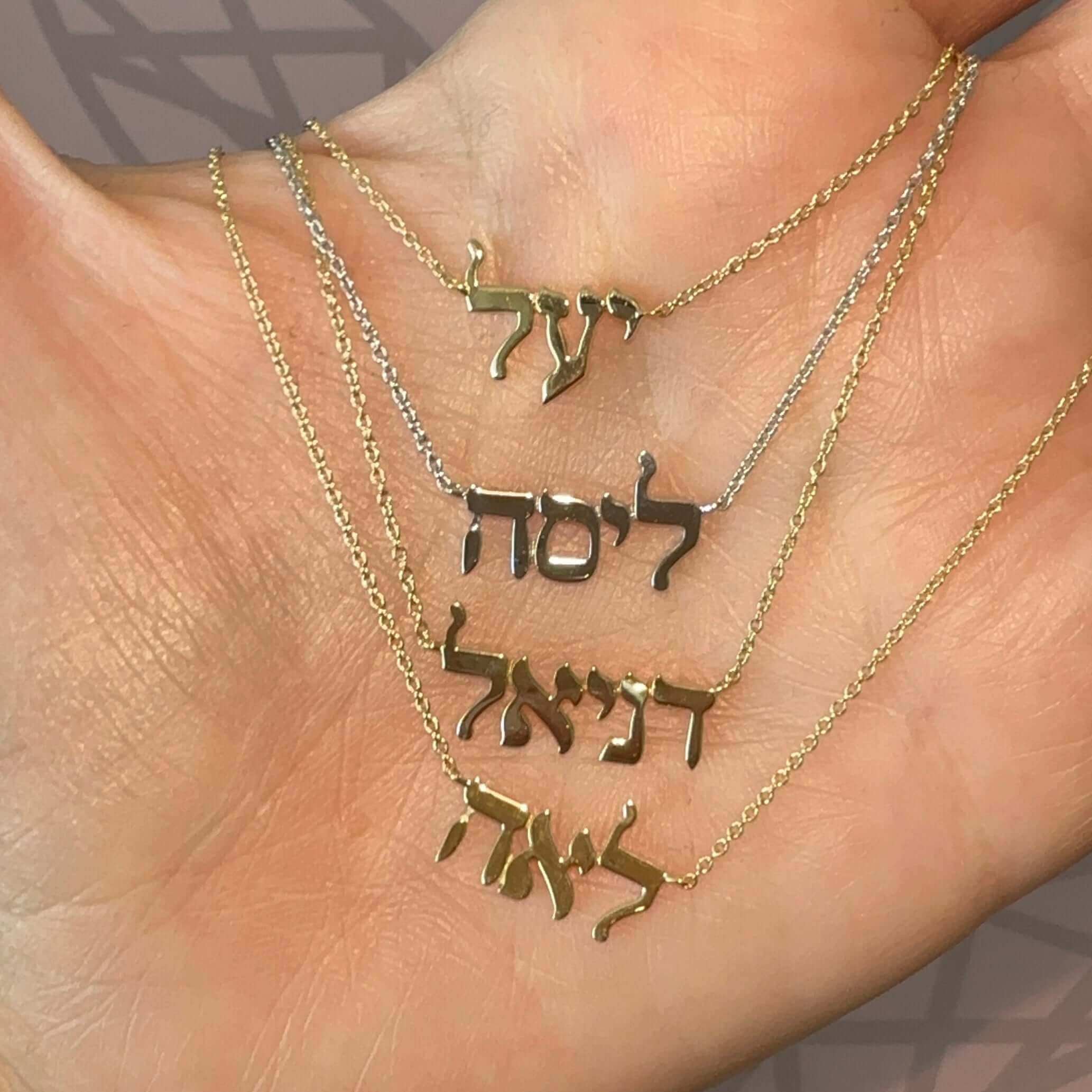 Personalized Hebrew Nameplate Gold Necklace displayed in hand, showcasing custom Hebrew names.