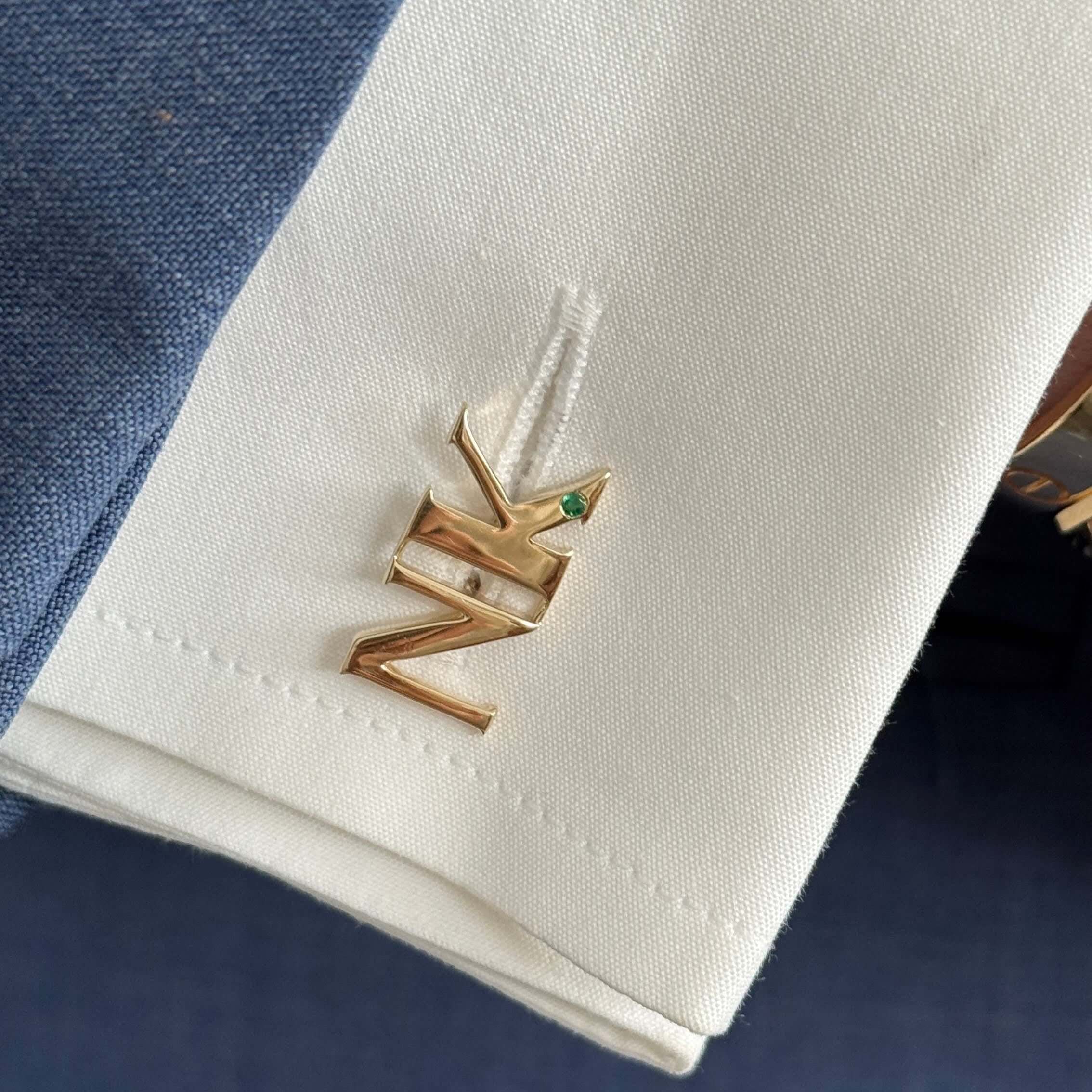 14K gold personalized initials cufflinks with gemstone accent on a dress shirt cuff.