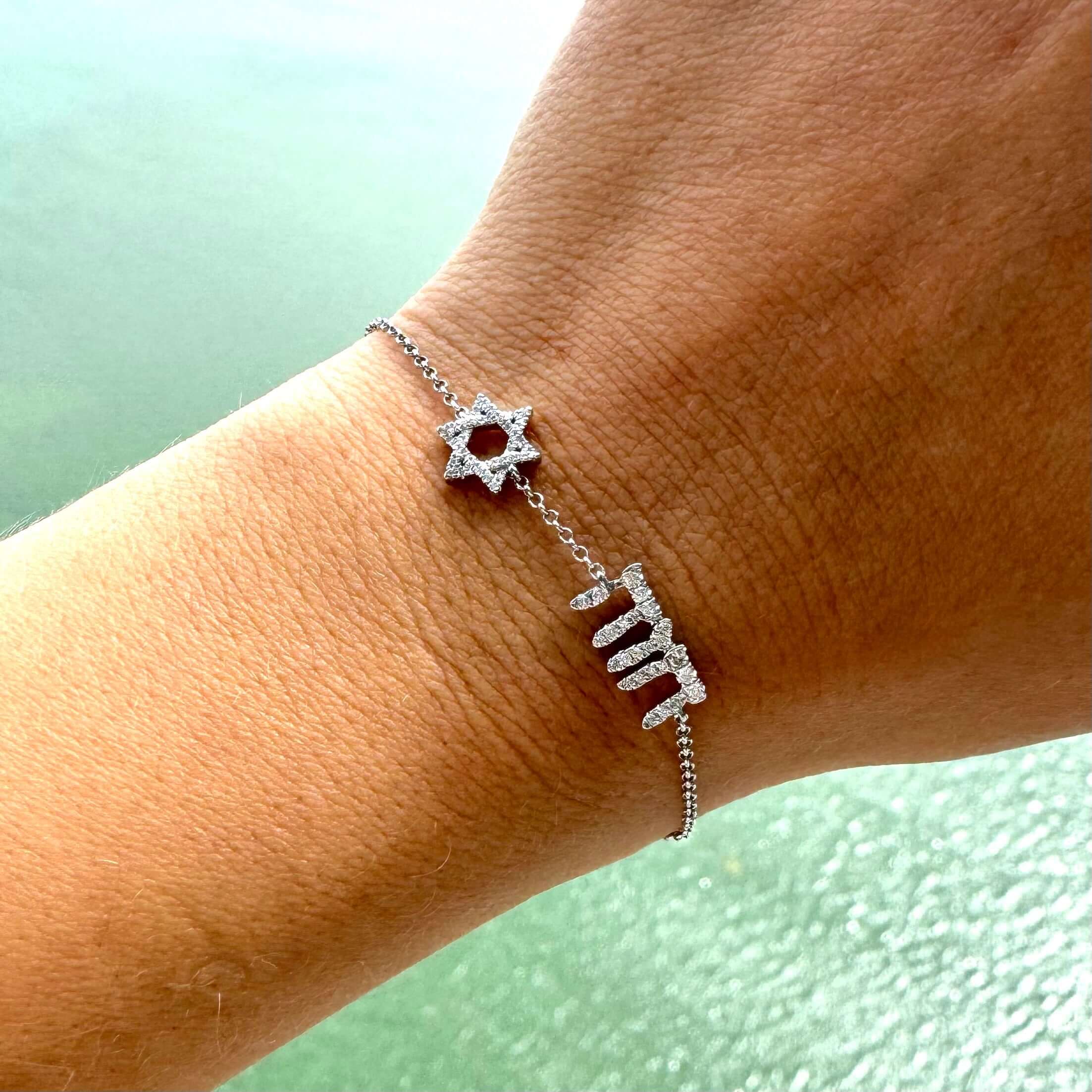 Personalized Motif Hebrew Diamond Nameplate Bracelet on a wrist with a Star of David motif from Izakov Fine Jewelry.