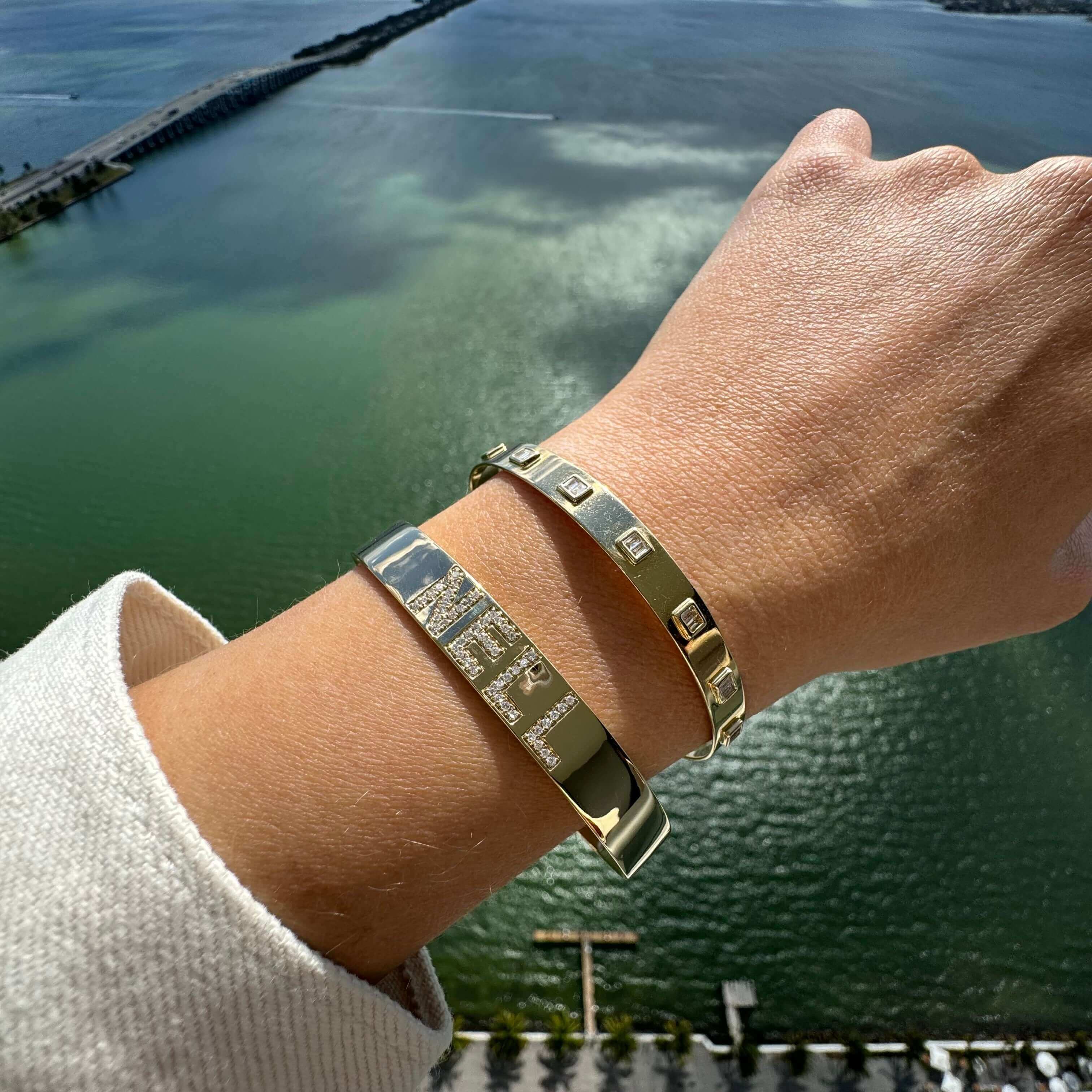 Gold and silver luxury bracelets from our jewelry brand with ocean view background