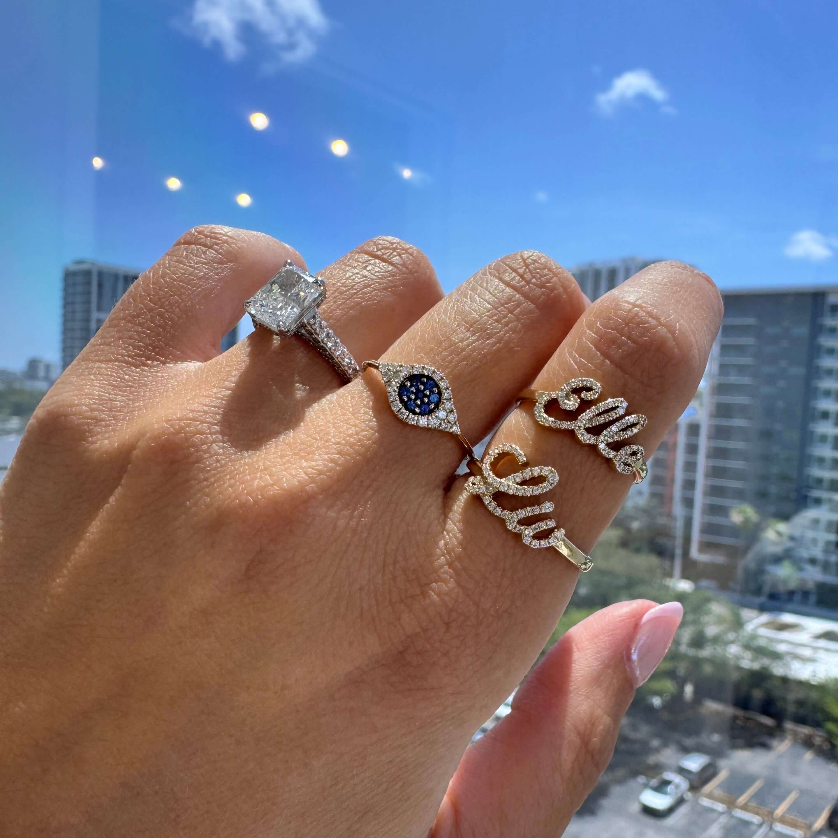 14K Gold Personalized Script Nameplate Diamond Ring showcased on hand with additional diamond rings.