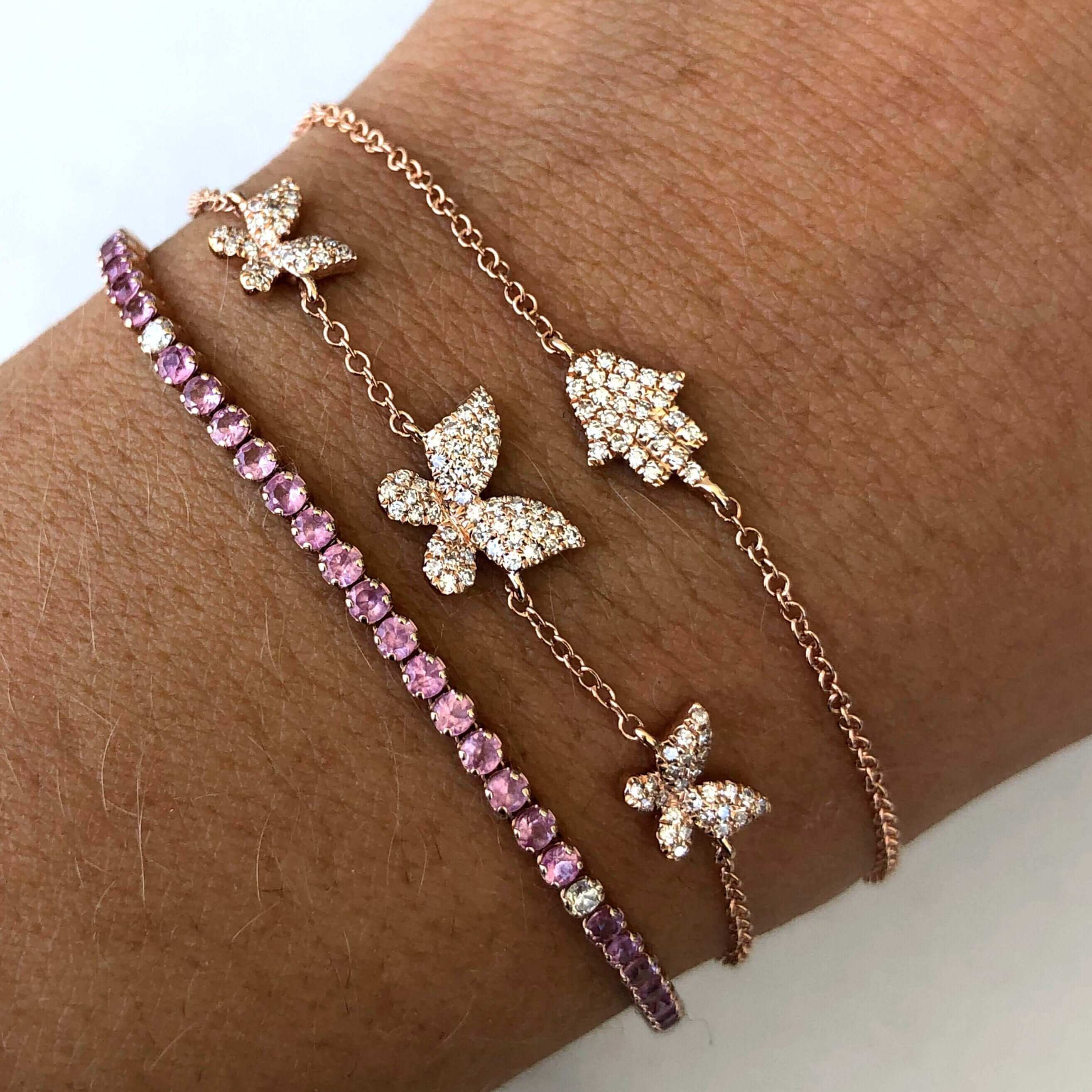 Rose gold butterfly and pink gemstone bracelets from our luxury jewelry collection on wrist