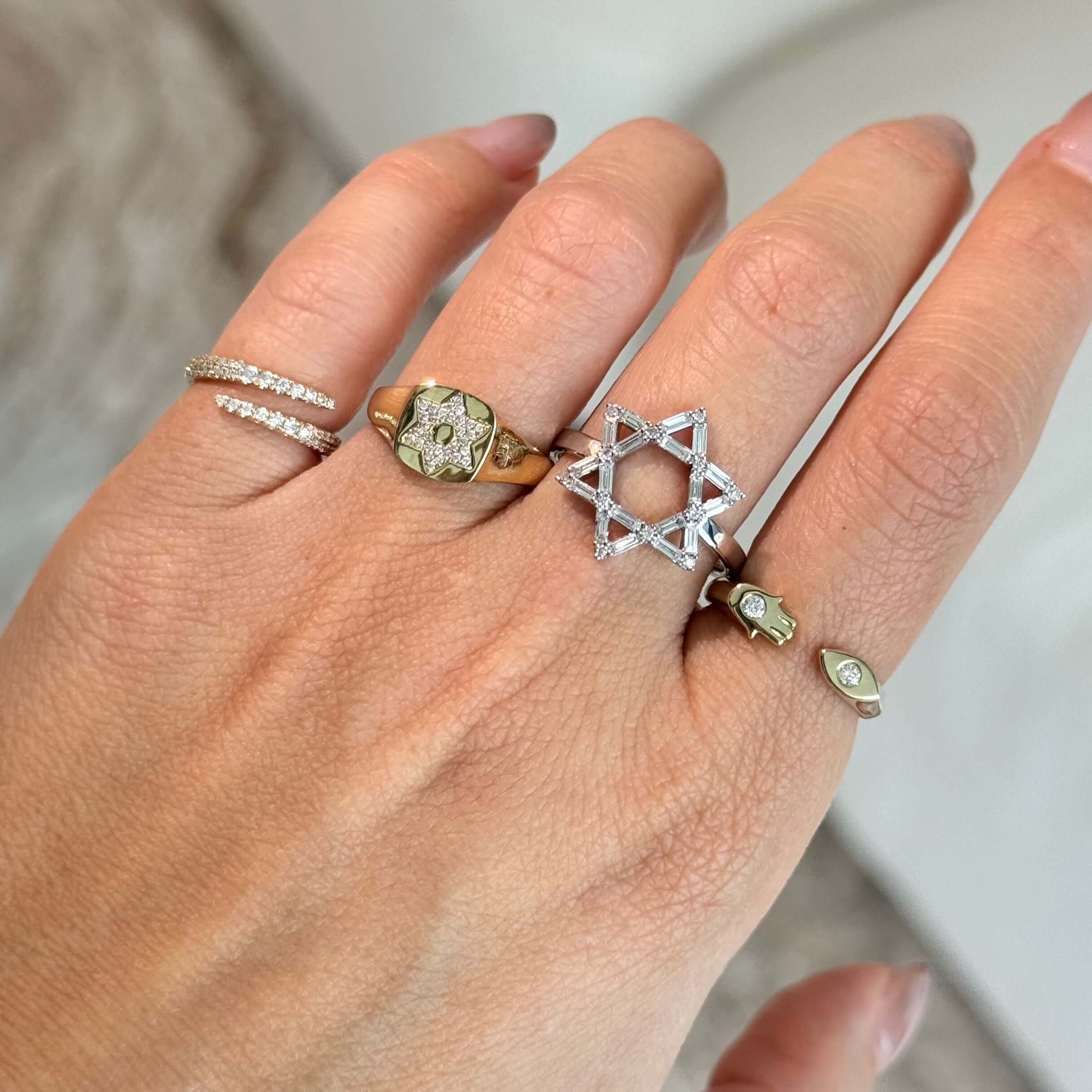 14K Gold Hamsa Evil Eye Open Diamond Ring worn alongside other stylish rings on a hand.