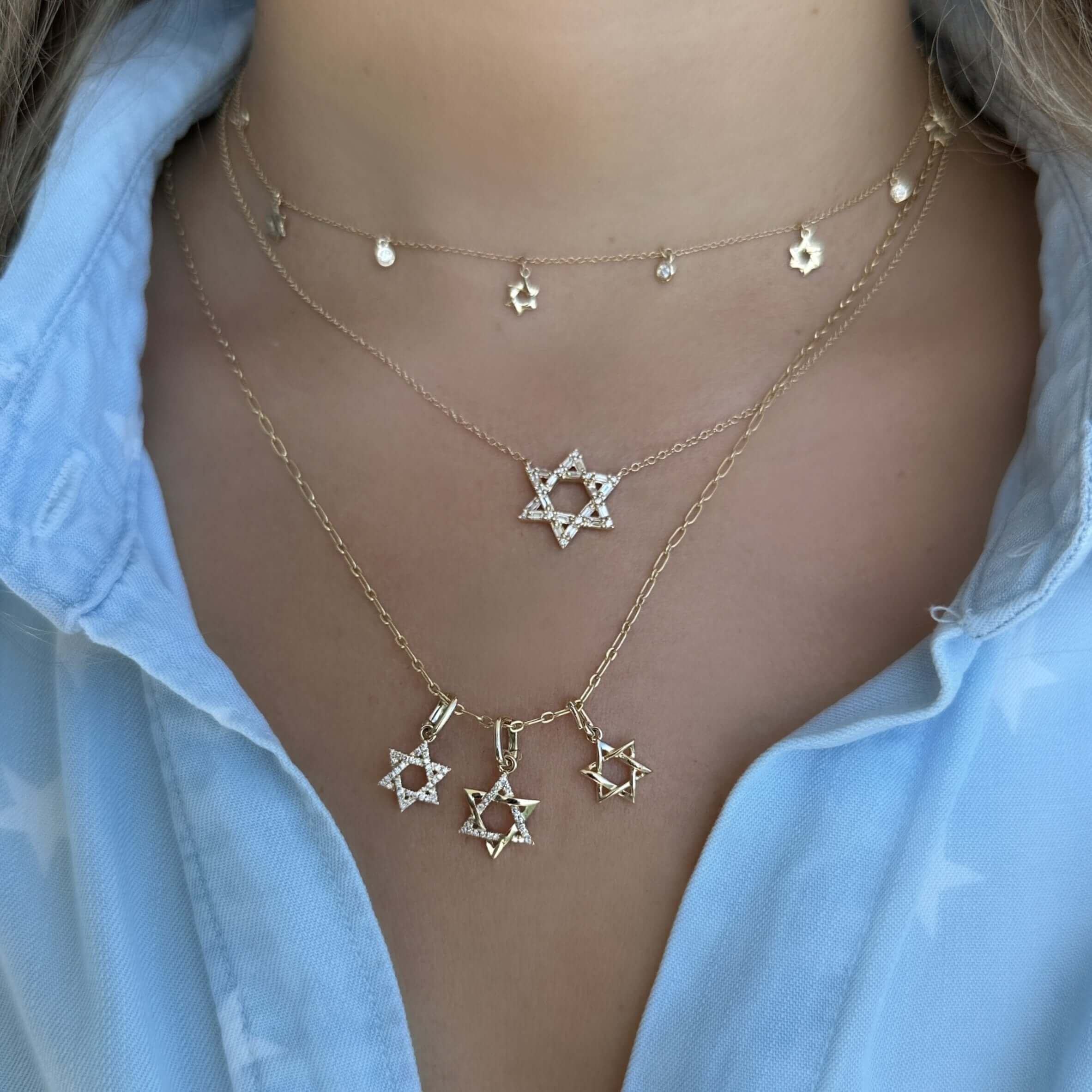 Woman wearing layered Star of David necklaces from our elegant jewelry collection.