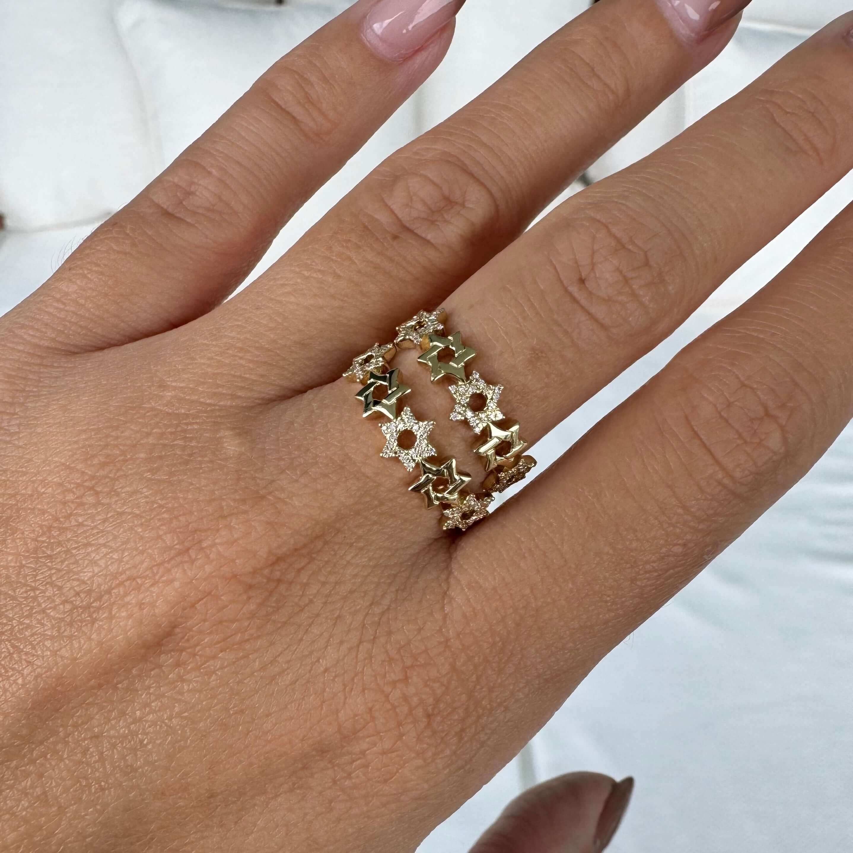 Elegant 14K gold Stars of David diamond ring showcasing alternating stars on a hand. Unique faith-inspired jewelry design by Izakov.