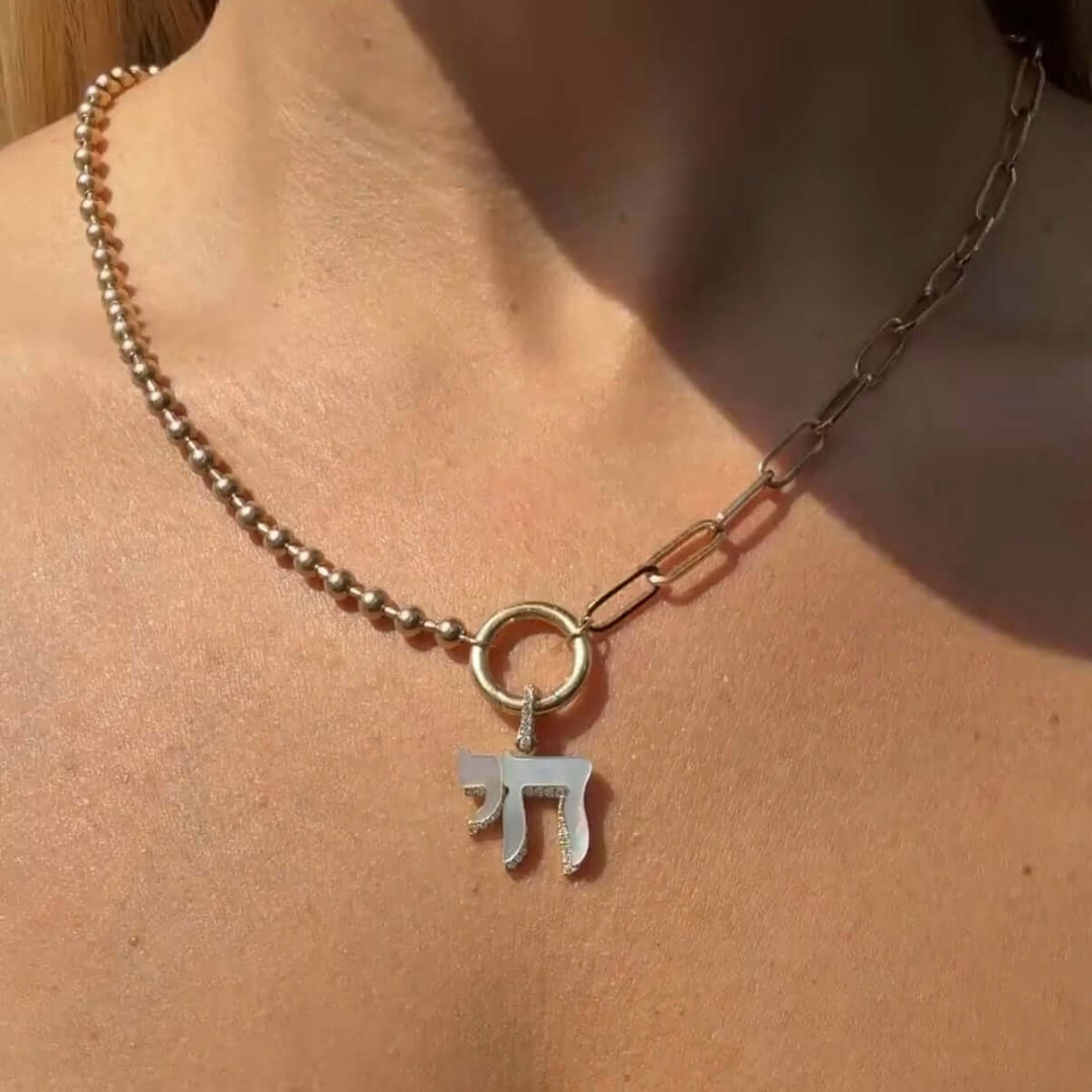 Close-up of Hebrew Chai Gemstone Diamond Shadow Pendant © worn on a stylish chain necklace.