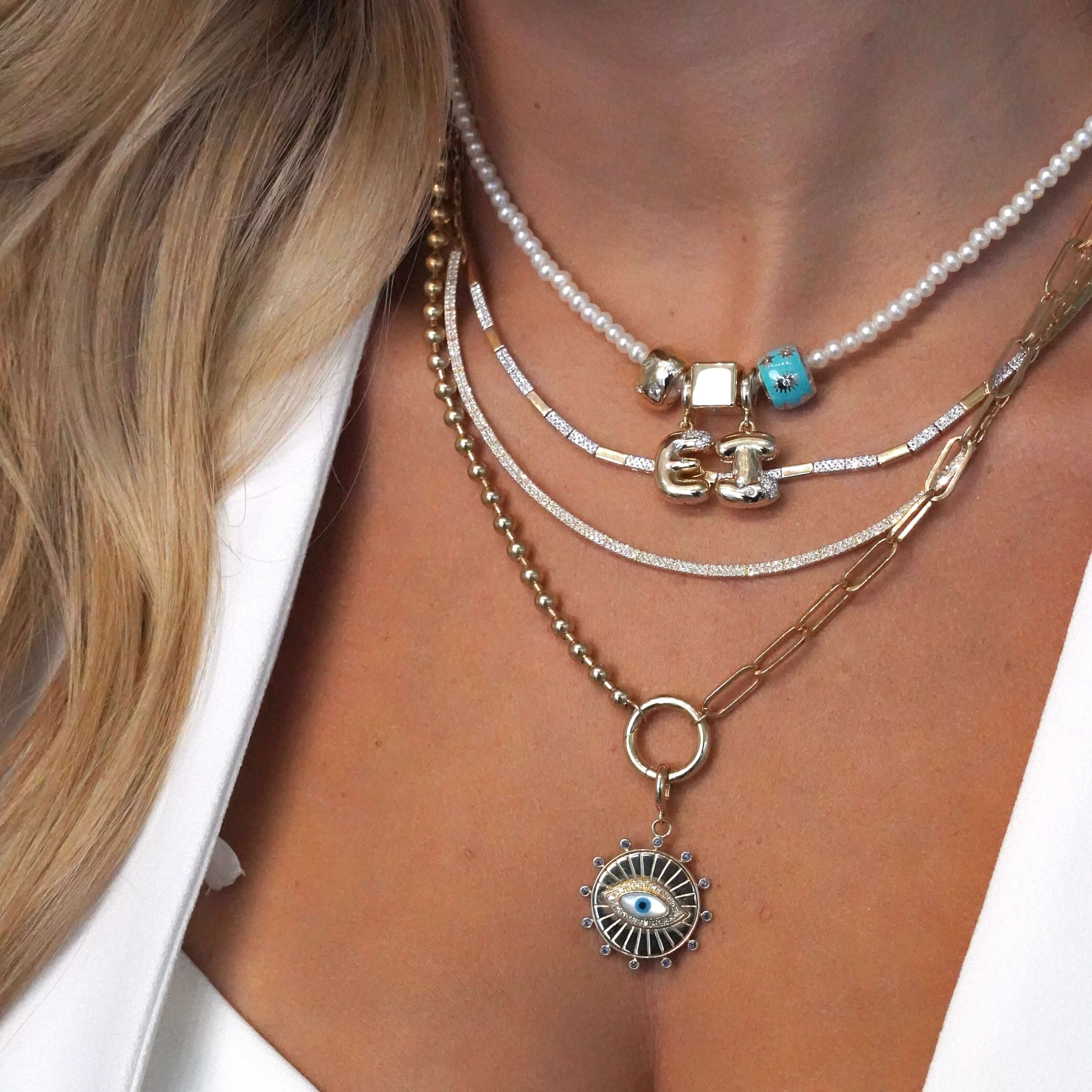 Elegant layered necklaces including a Pearl Beaded Necklace from Izakov Fine Jewelry, showcasing refined style and versatility.