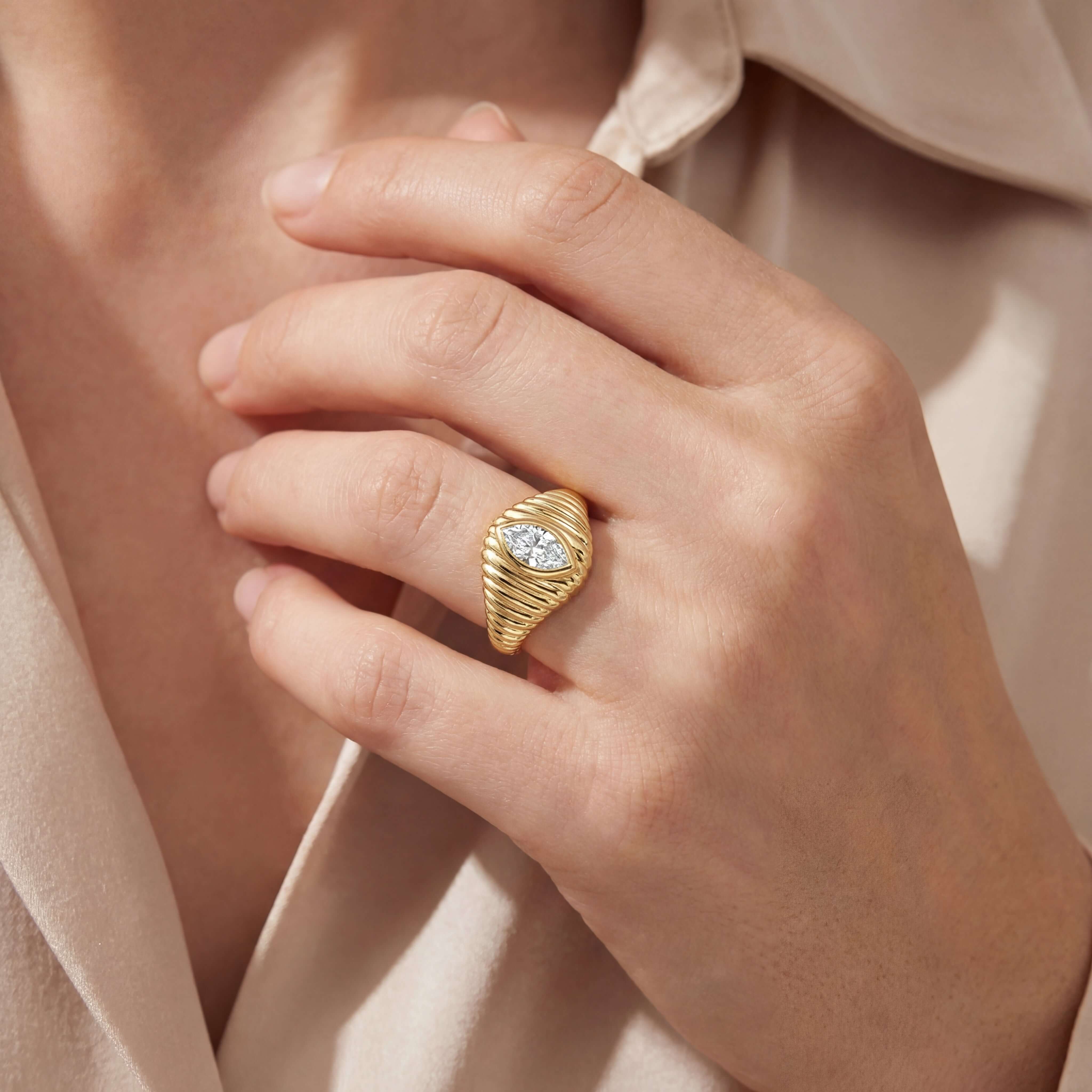 Radiating Bezel Set Marquise Diamond Signet Ring worn on a hand, featuring a marquise diamond in a 14k gold setting.