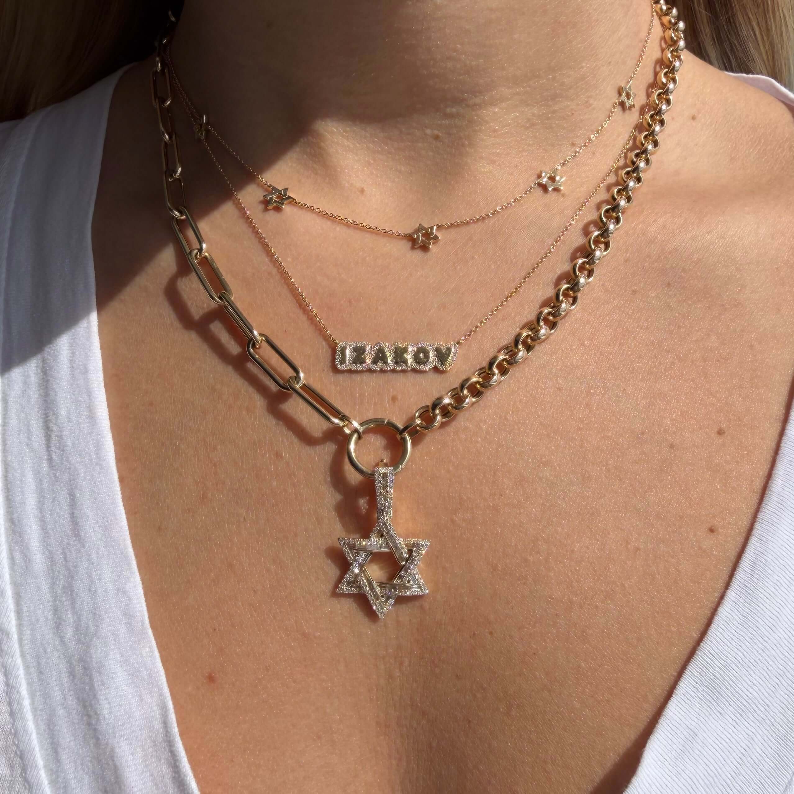 Baguette & Round Diamond Star of David Pendant on a layered gold necklace with sparkling diamonds.