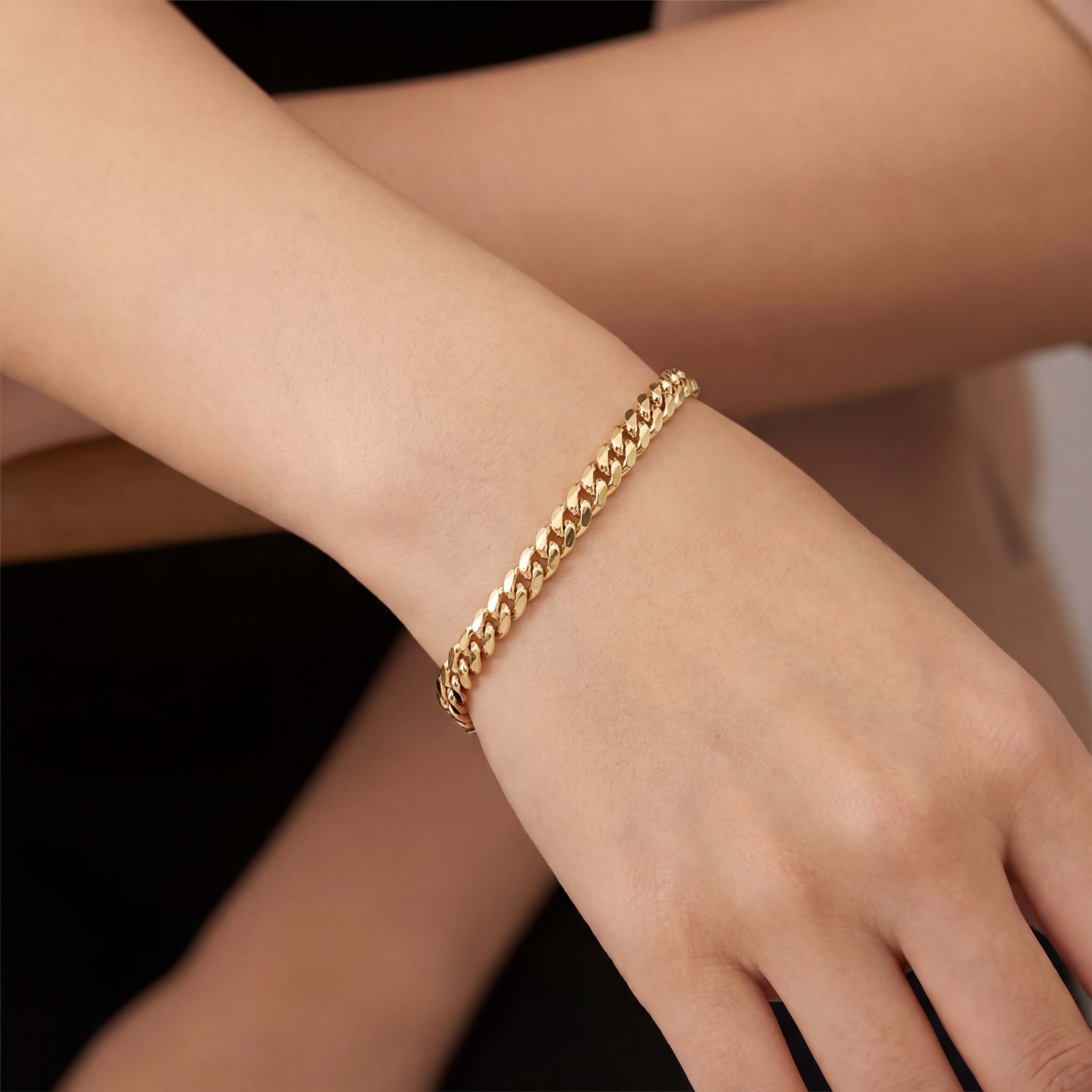 Classic Solid Miami Cuban Link Gold Bracelet worn on a wrist, showcasing its flat profile and elegant design.