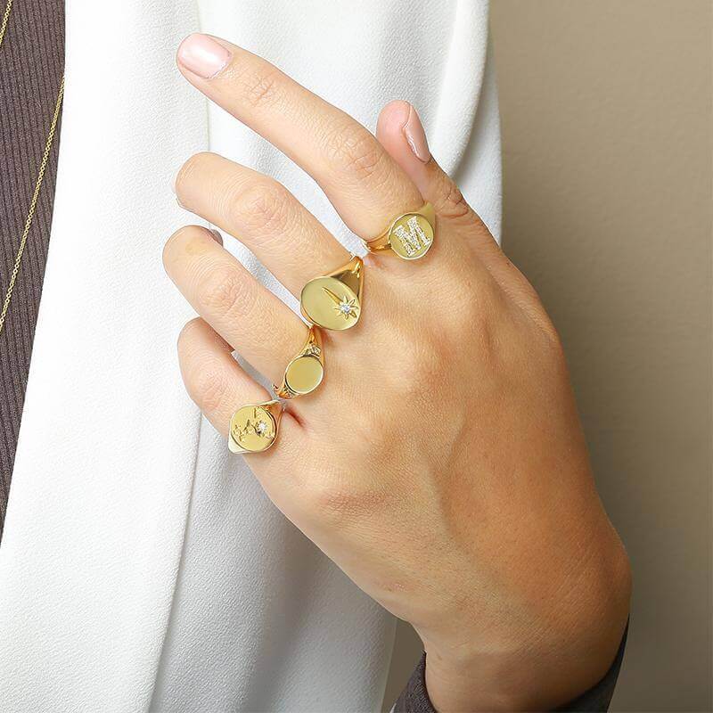 Hand adorned with elegant gold rings displaying intricate designs from our luxury jewelry collection