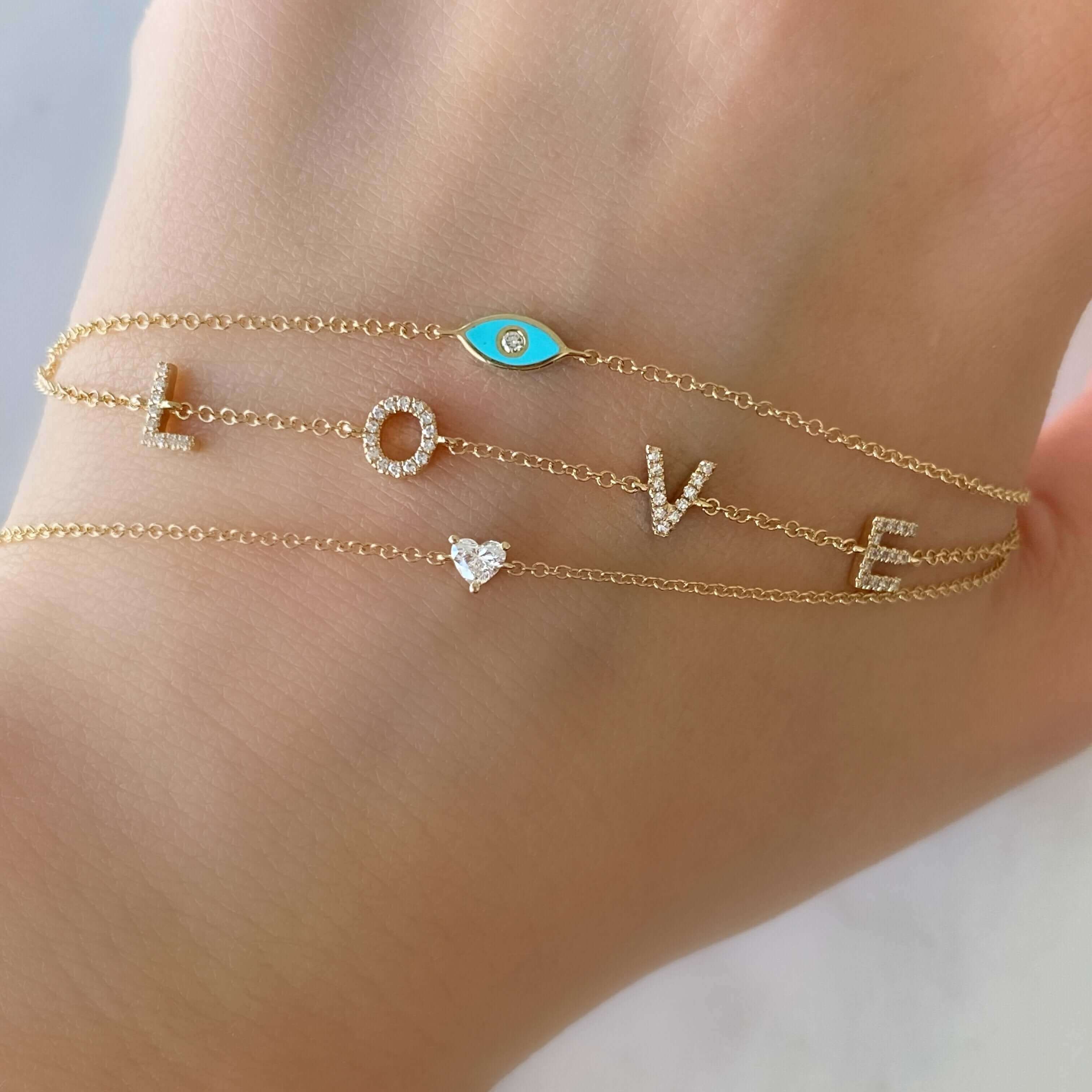 "Elegant gold bracelet featuring 'LOVE' letters and a turquoise charm, designed by our jewelry brand"