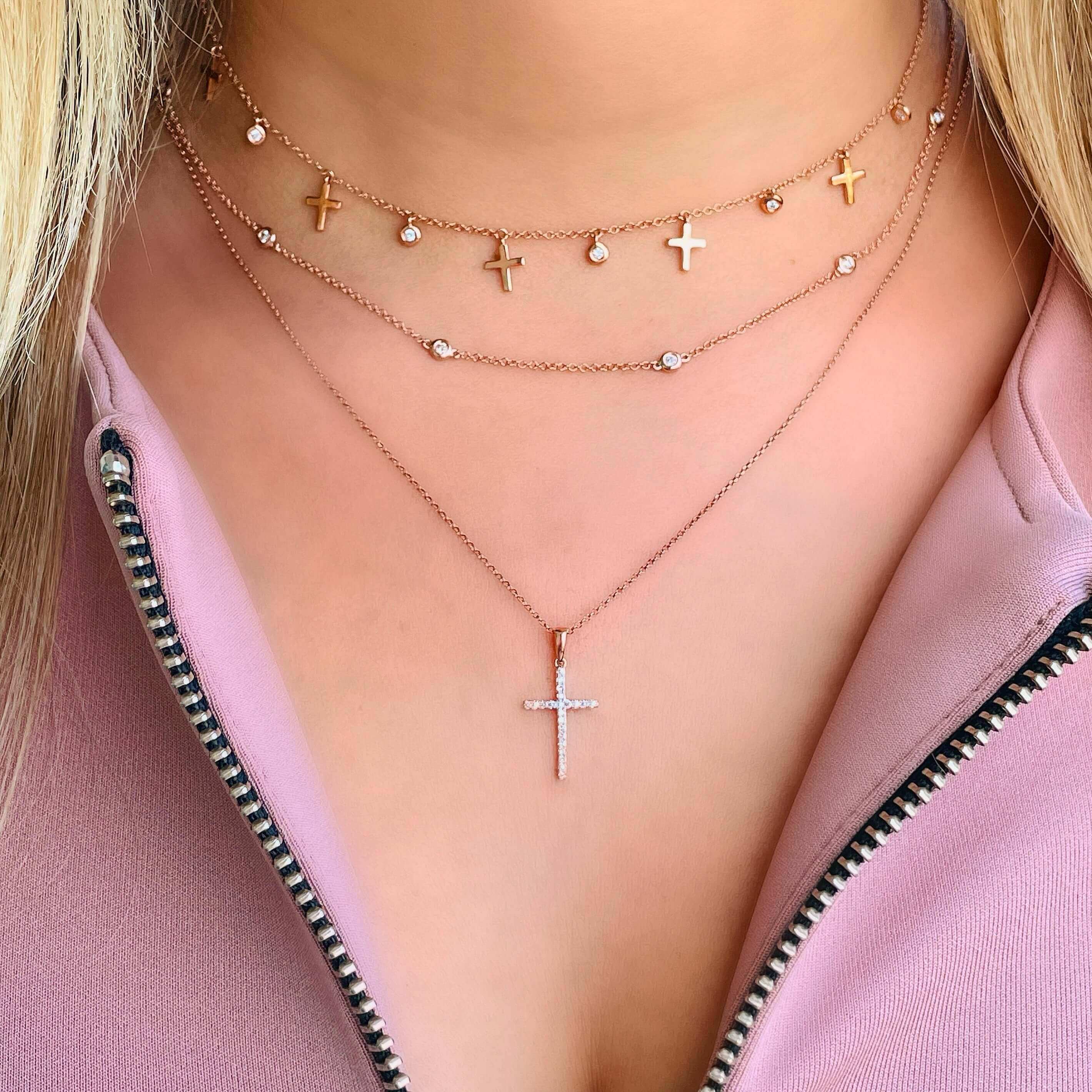 Layered gold and diamond cross necklaces from our elegant jewelry collection, perfect for a stylish and modern look.