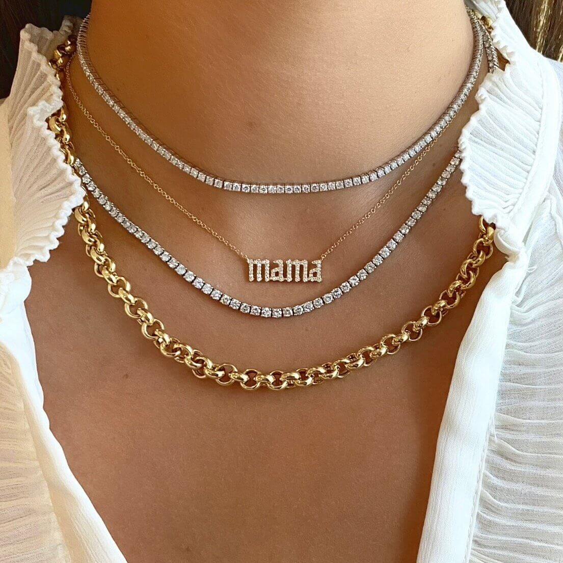 Woman wearing layered gold and diamond necklaces, including a "mama" pendant, showcasing elegant jewelry from our brand.
