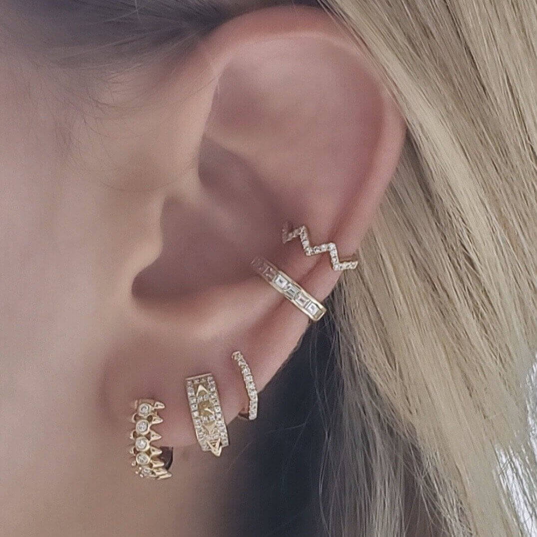 Woman wearing stylish gold and diamond ear cuffs from our jewelry brand collection