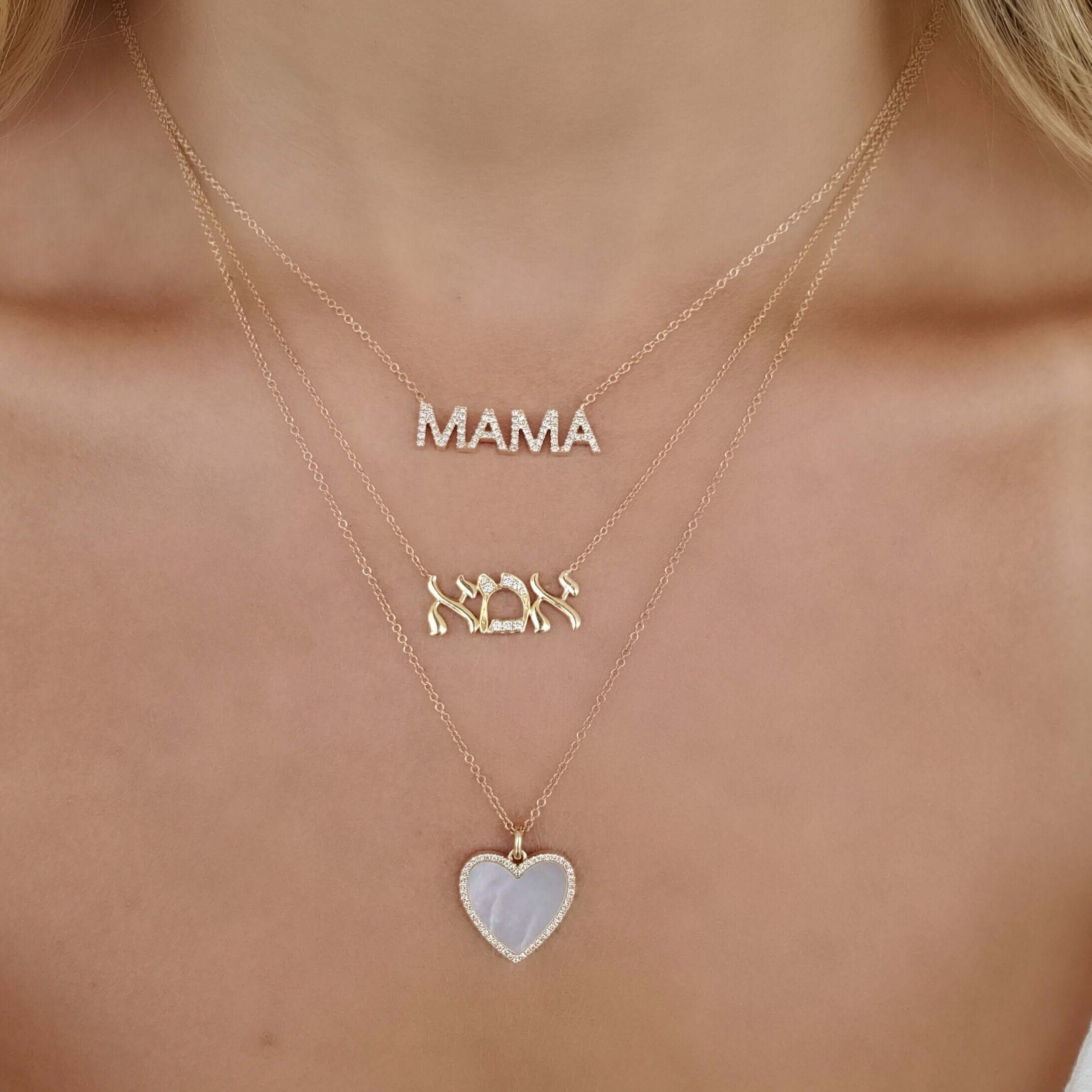 Woman wearing layered necklaces with "MAMA" pendant, family figures, and heart pendant from our exclusive jewelry collection.
