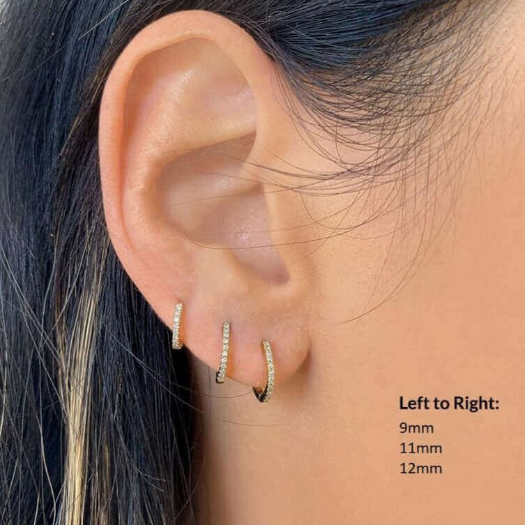 Woman wearing three sizes of gold hoop earrings, showcasing 9mm, 11mm, and 12mm options from our jewelry collection.