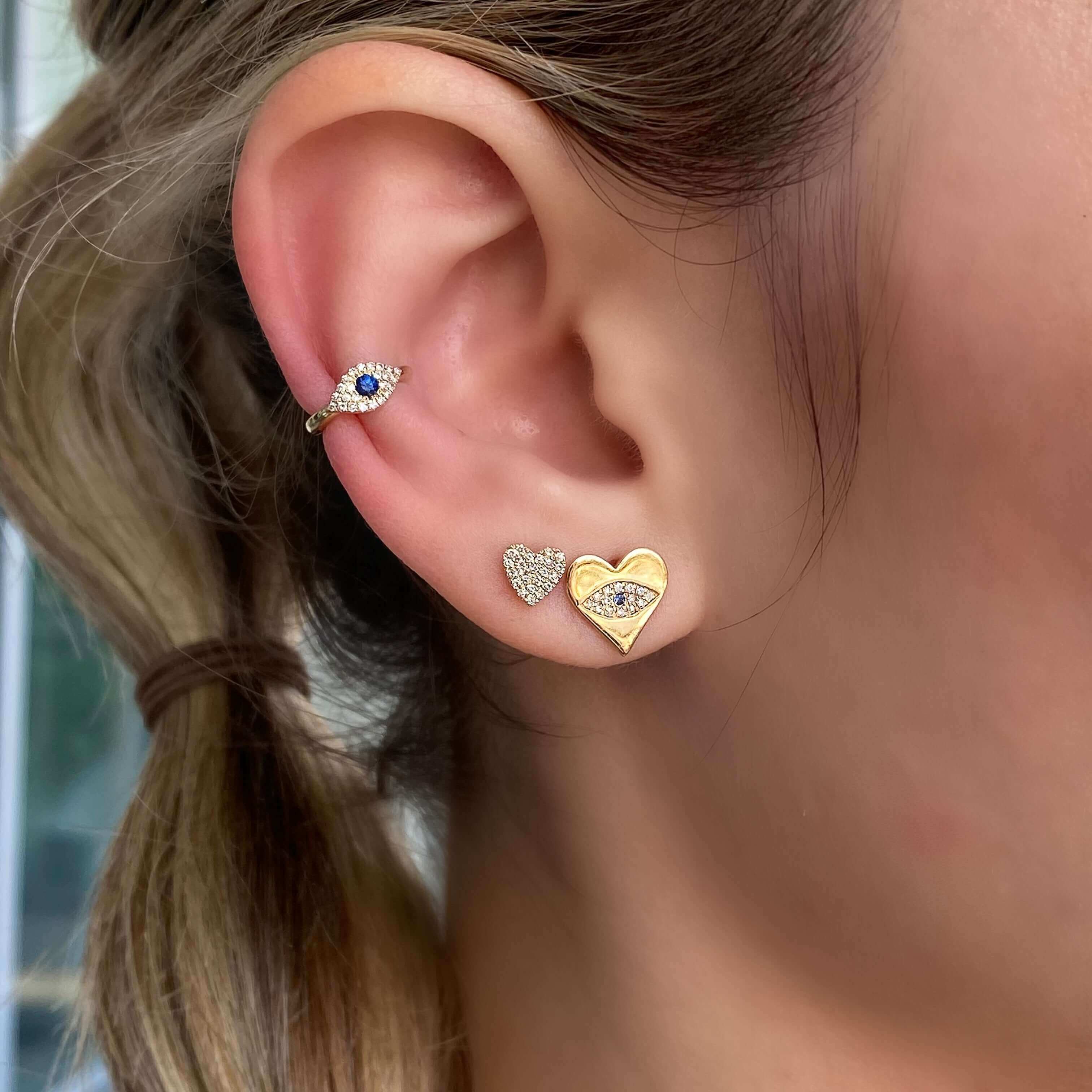 Woman wearing elegant gold heart and diamond stud earrings from our jewelry brand