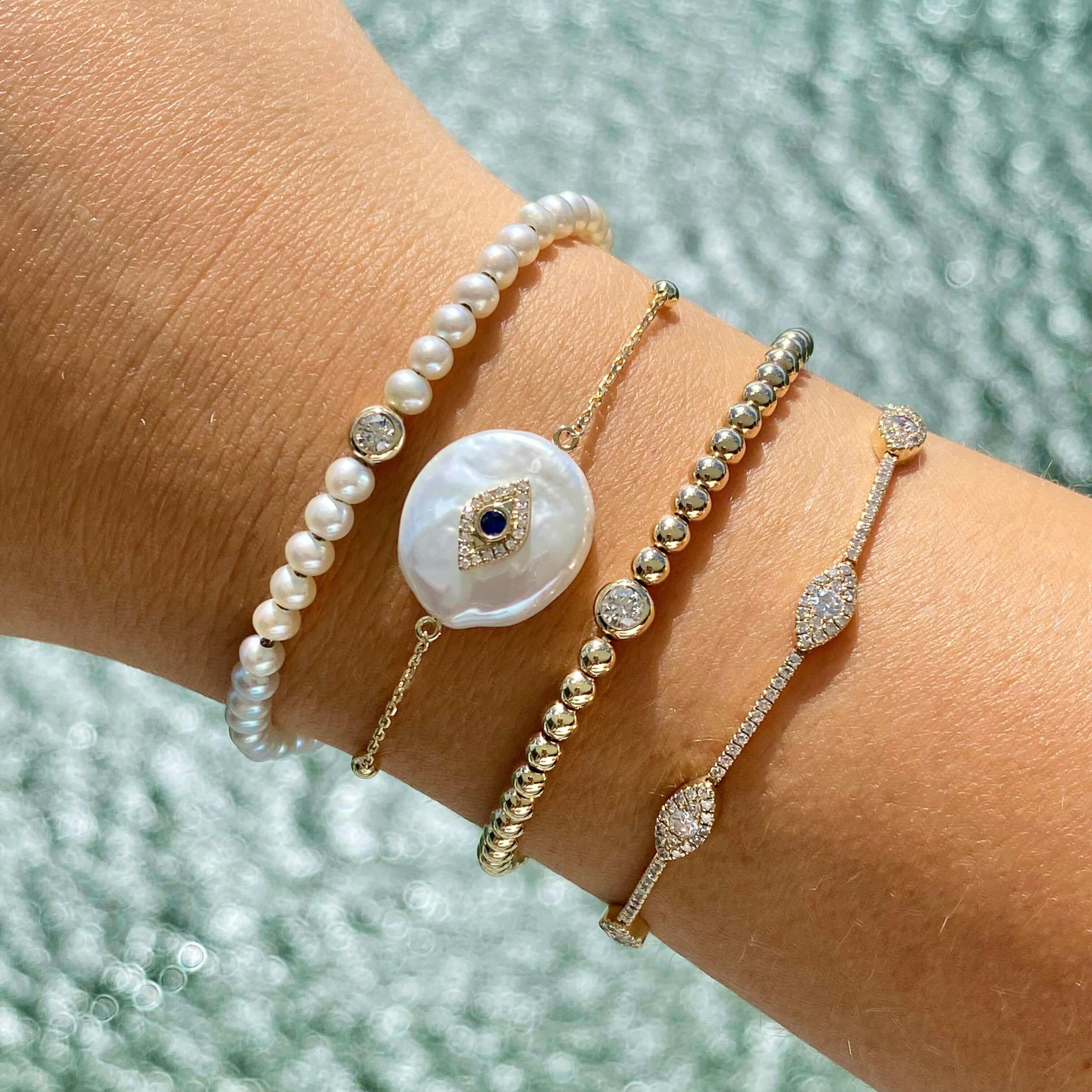 Luxurious collection of gold and pearl bracelets featuring intricate designs and gemstone accents from our premium jewelry brand.
