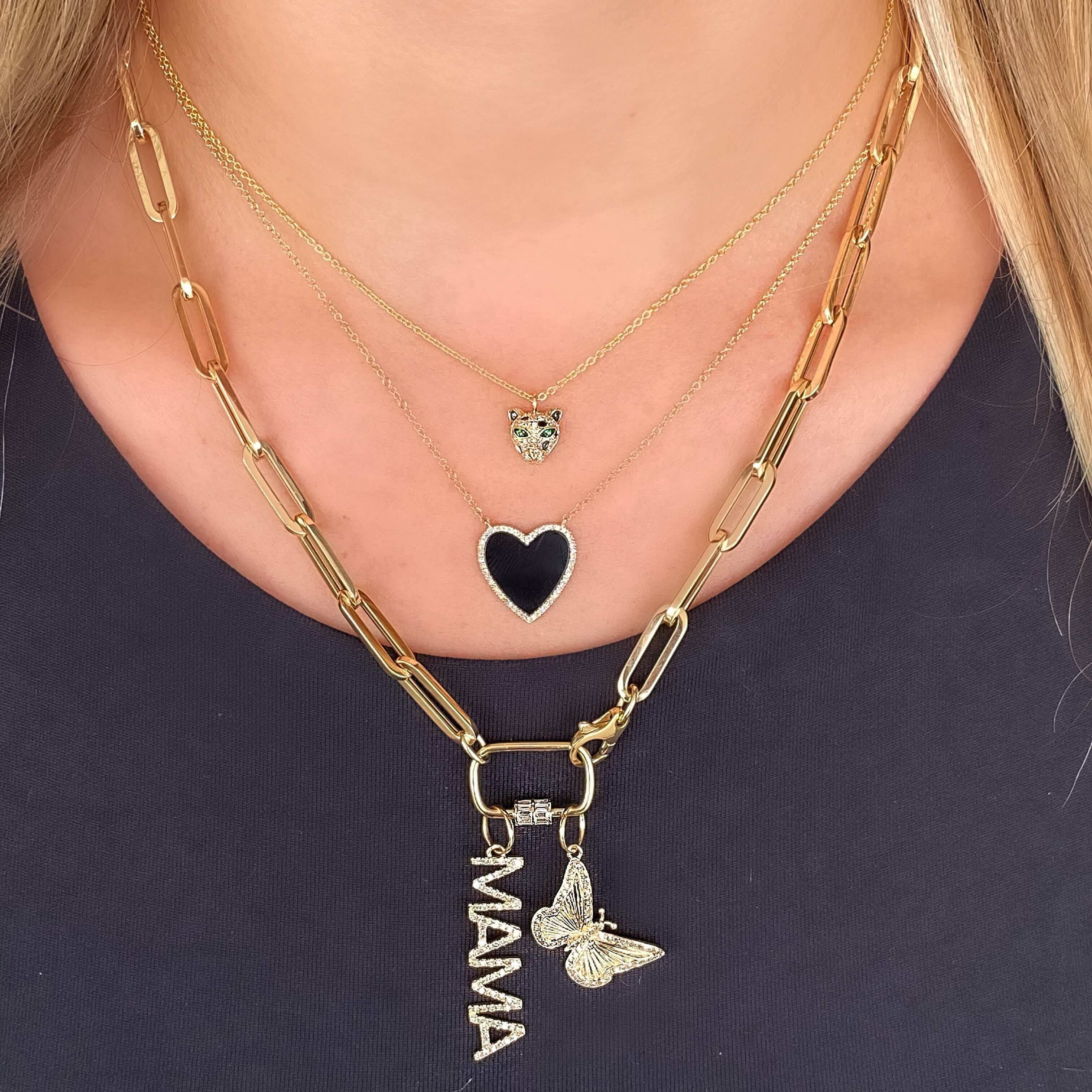 Layered gold necklaces with heart and butterfly pendants, "MAMA" charm, representing our elegant jewelry collection.
