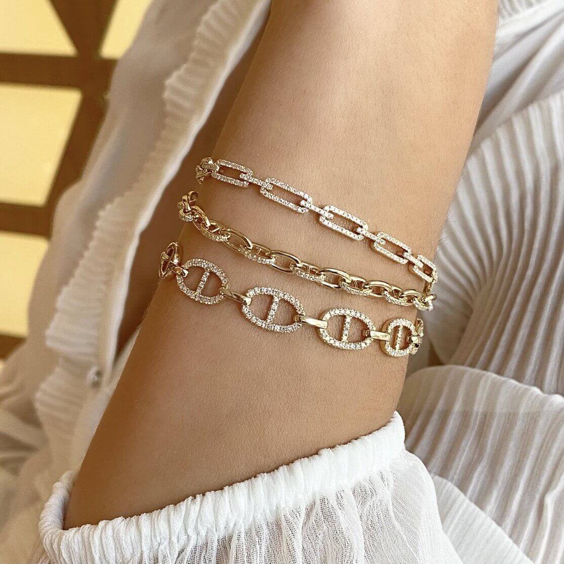 Woman wearing elegant gold bracelets with luxury chain designs from our jewelry brand.