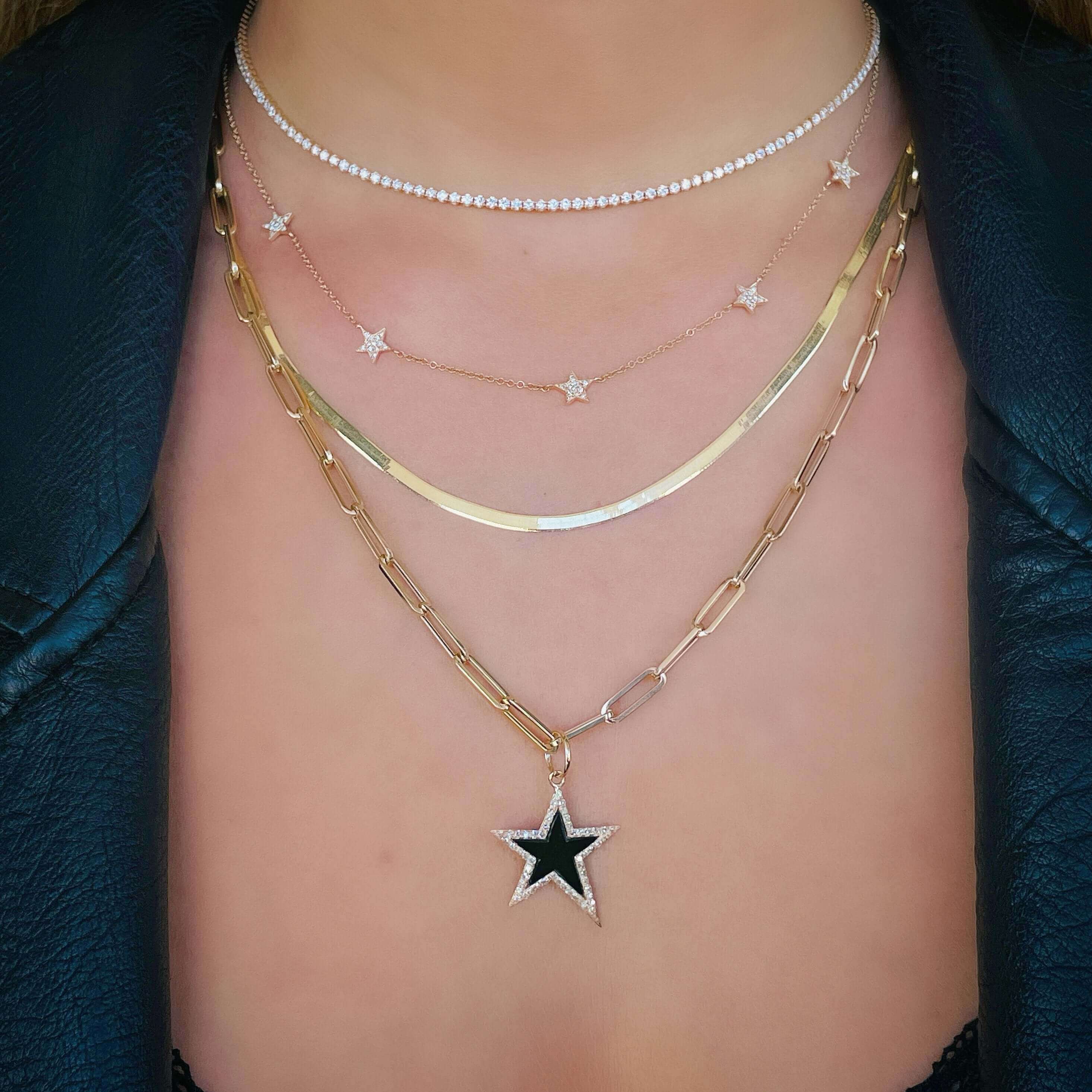 Woman wearing layered gold and silver necklaces with star pendants from our jewelry brand.