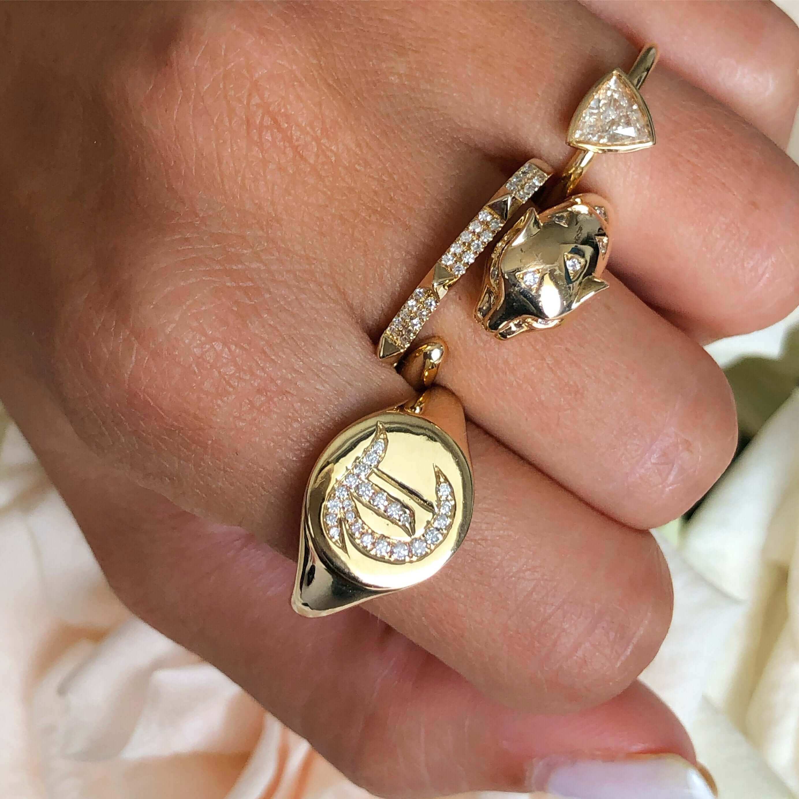 Stylish gold rings with unique designs and diamond accents on a woman's hand, highlighting luxury jewelry from our brand