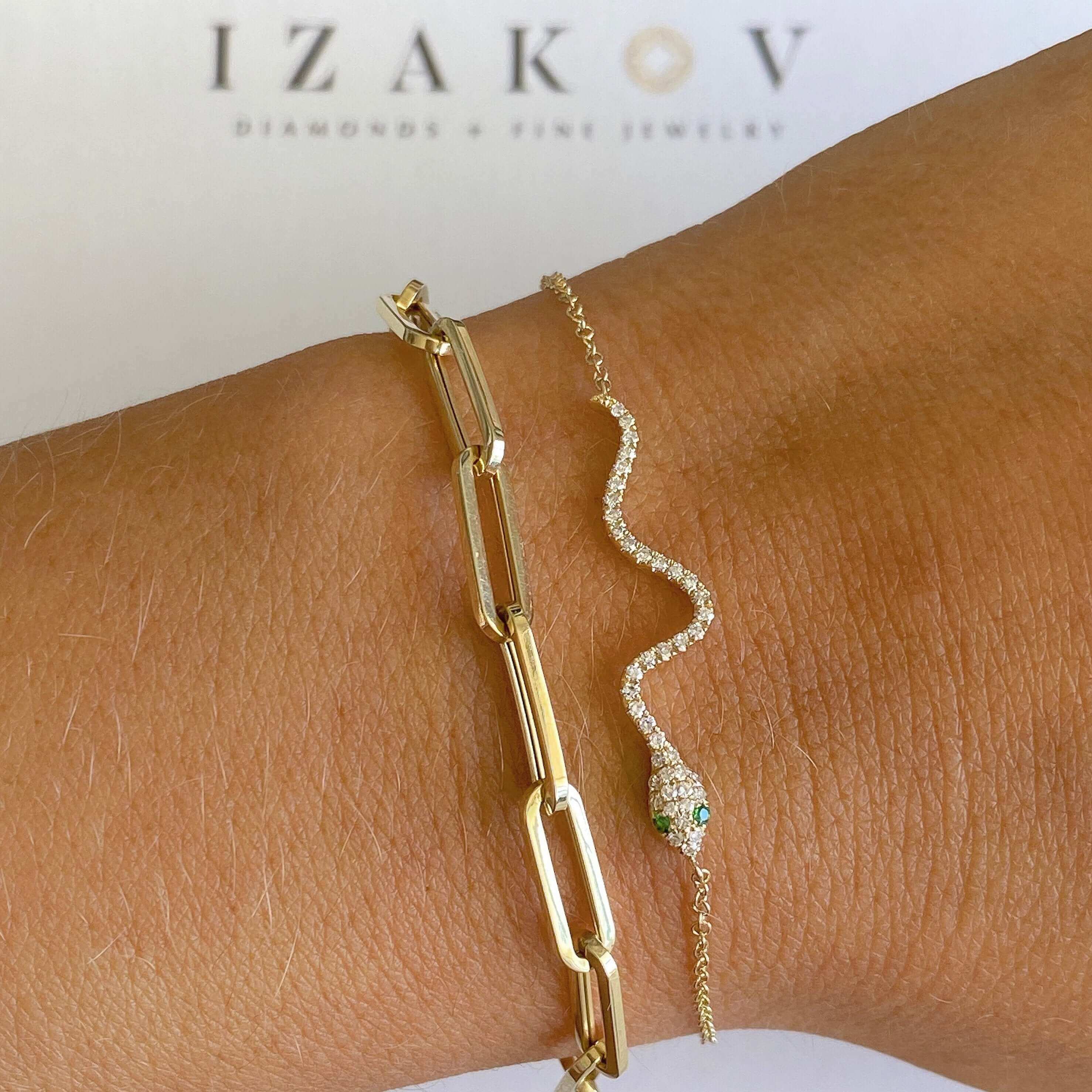 Elegant gold bracelet and diamond-encrusted snake bracelet from Izakov Diamonds & Fine Jewelry displayed on a wrist