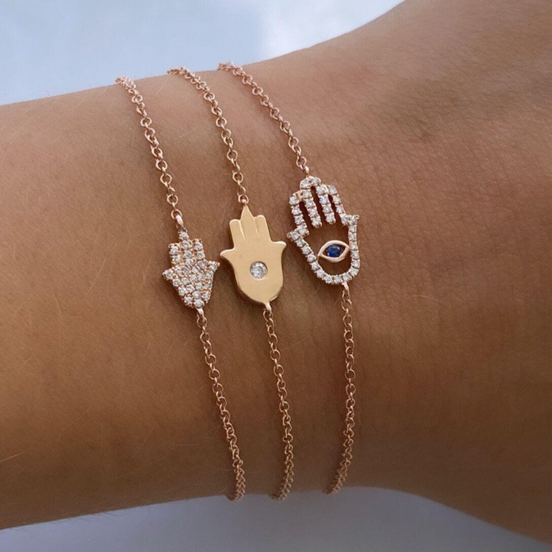 Rose gold Hamsa hand bracelets with diamond accents on wrist, elegant jewelry from our brand collection.