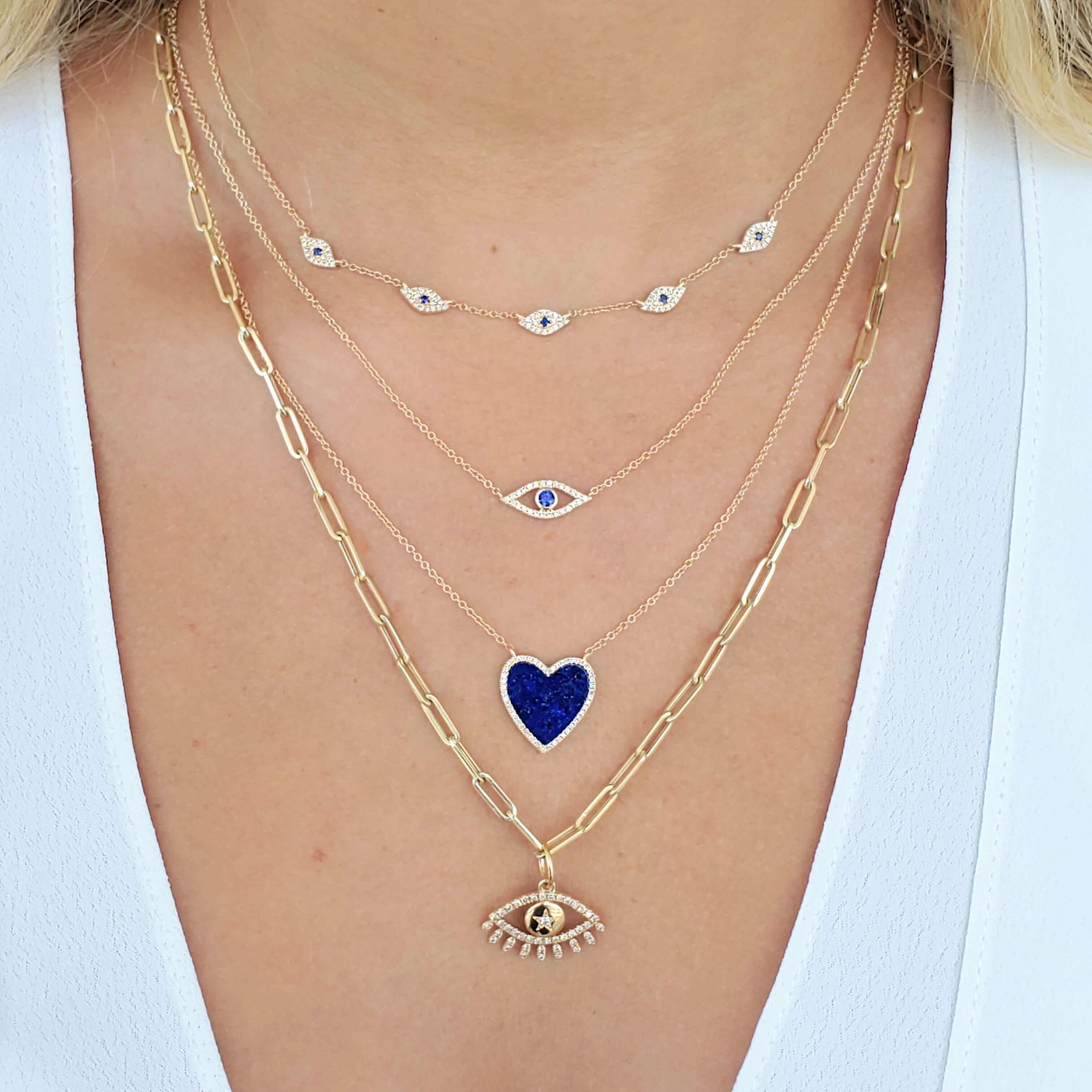 Layered gold necklaces with blue heart and evil eye pendants, elegant jewelry from our brand