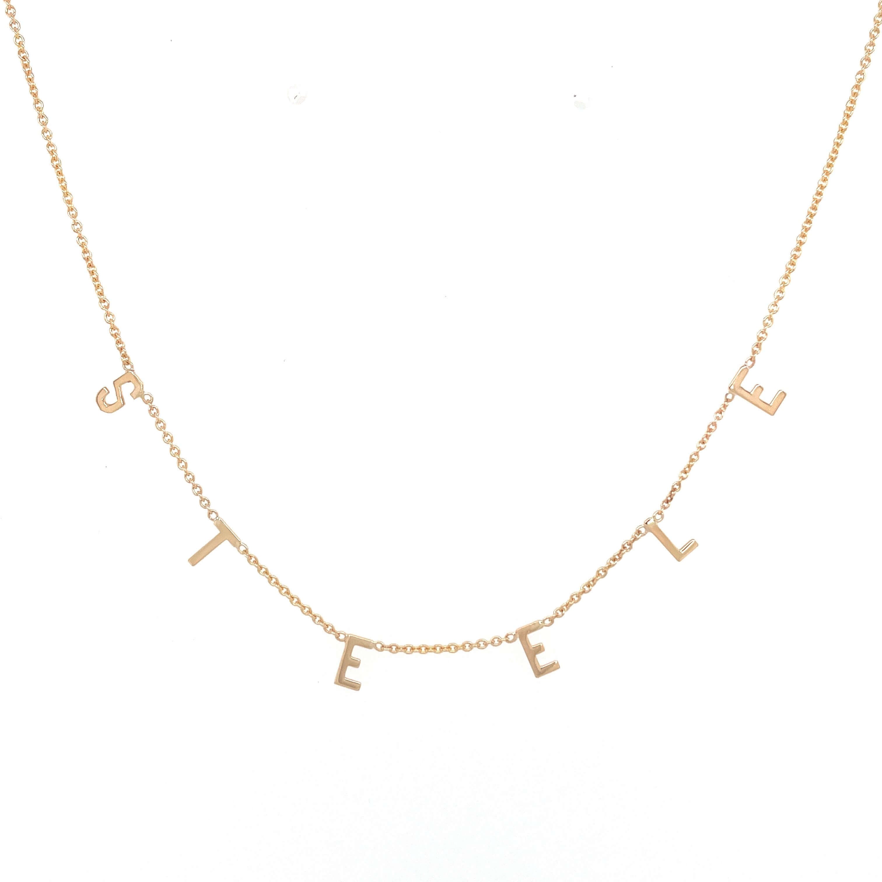 Gold necklace with delicate letters spelling "STEEL," showcasing our premium jewelry brand's elegant and personalizable designs.