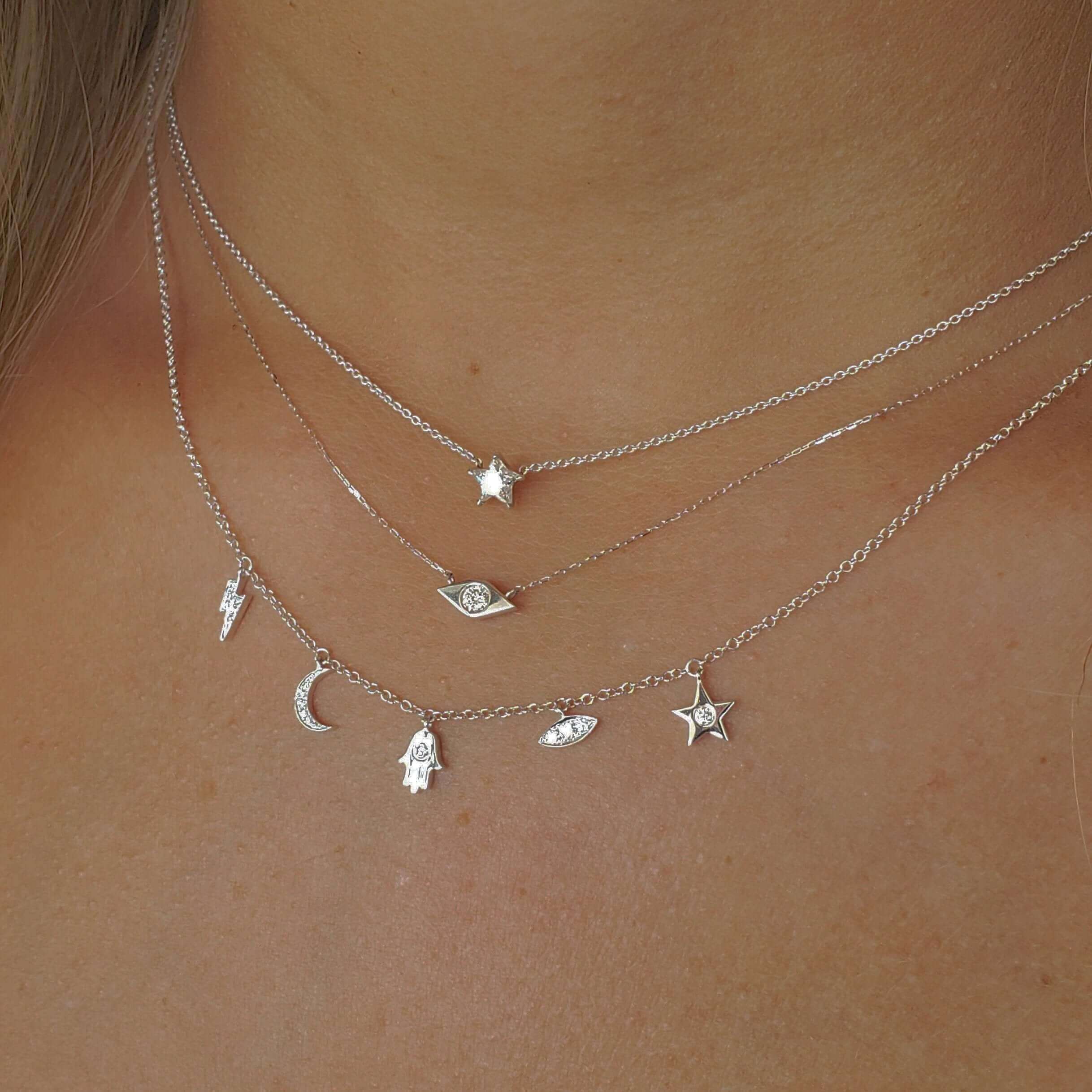 Layered silver necklaces with celestial and star charms, perfect for adding elegance to any look.